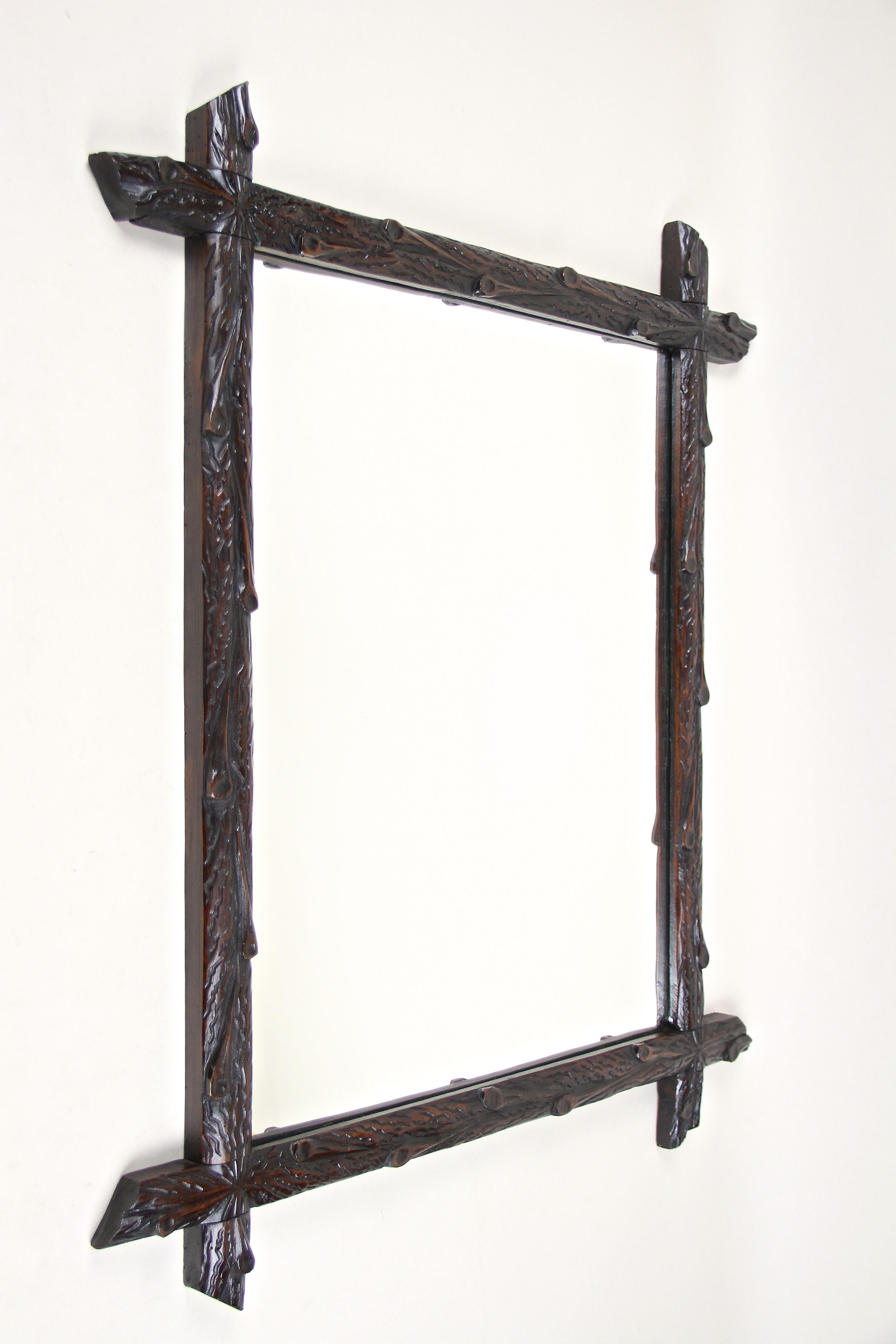 Unique Black Forest wall mirror from the late 19th century in Austria. Around 1880 this rustic wooden mirror has been elaborately hand carved out of basswood showing a very uncommon 