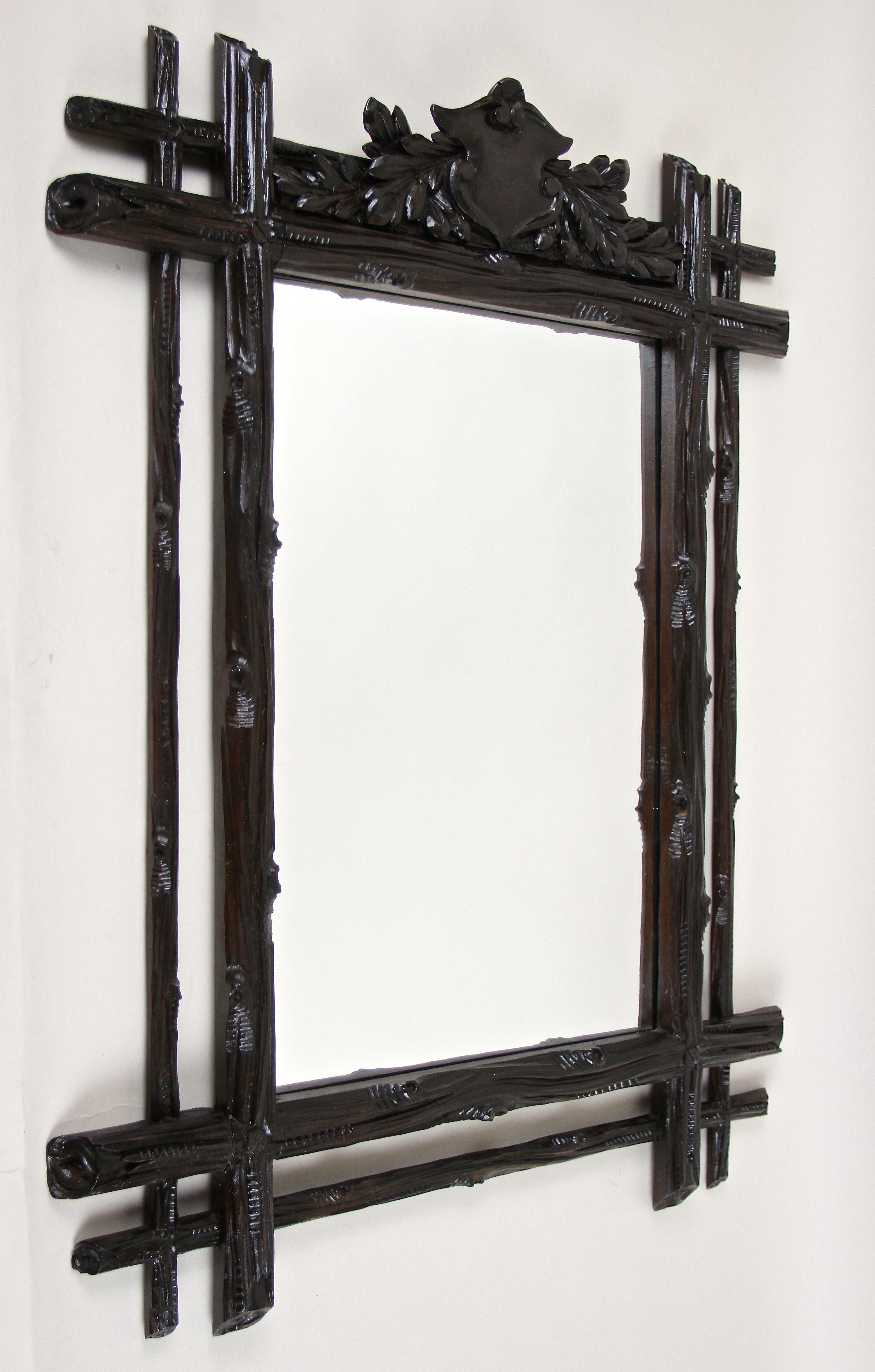 Fantastisch aussehender rustikaler Schwarzwälder Wandspiegel aus dem späten 19. Jahrhundert in Österreich um 1870. Handgeschnitzt aus feinem Lindenholz zeigt dieser ländliche Spiegel ein absolut erstaunliches Design. Der doppelte Rahmen mit