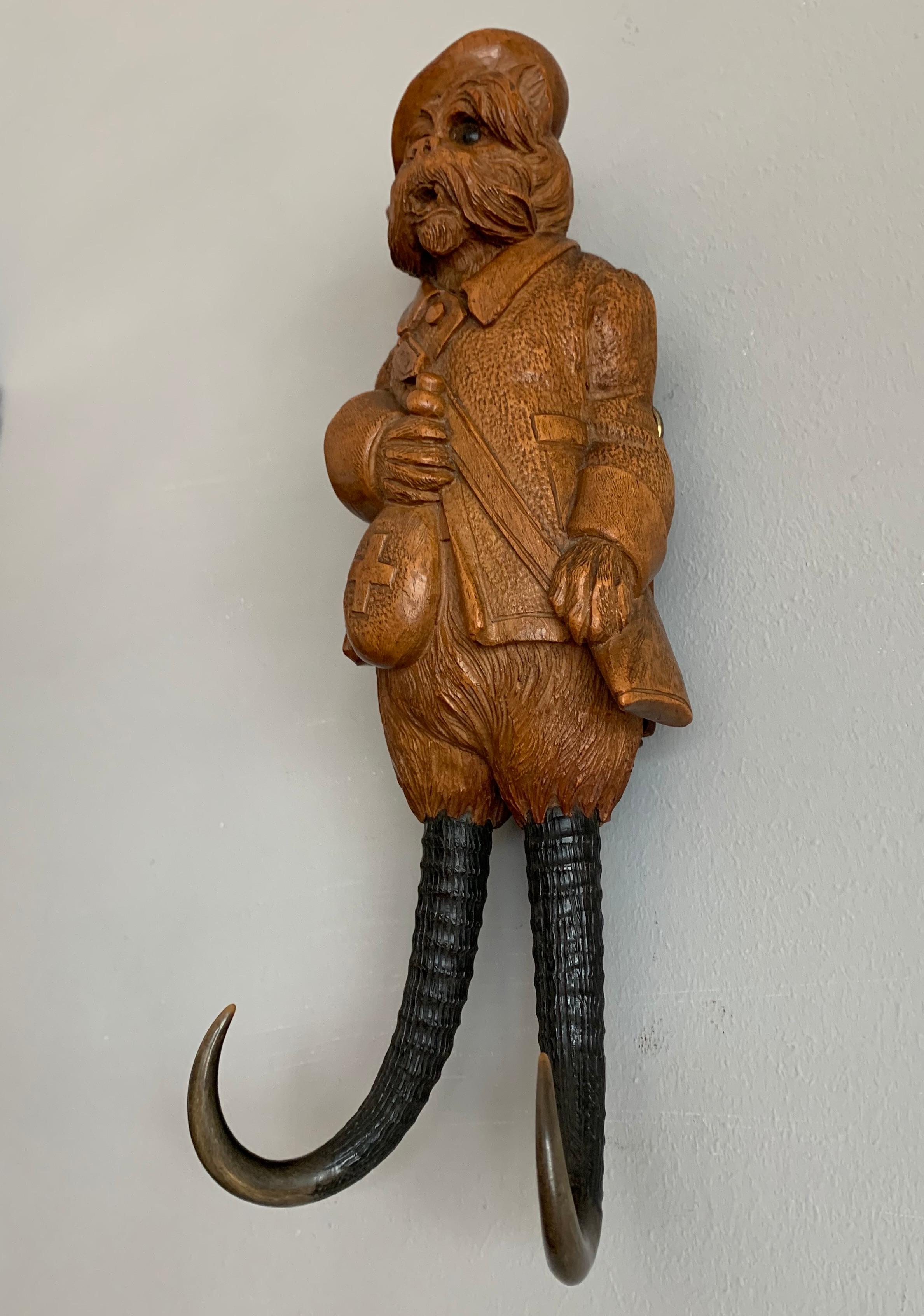 Stunning Swiss black forest whip hook of museum quality and condition.

This hand carved antique whip hook for wall mounting in the shape of a dog in a hunter's tunic is in excellent condition. If you are a collector of only the best quality and