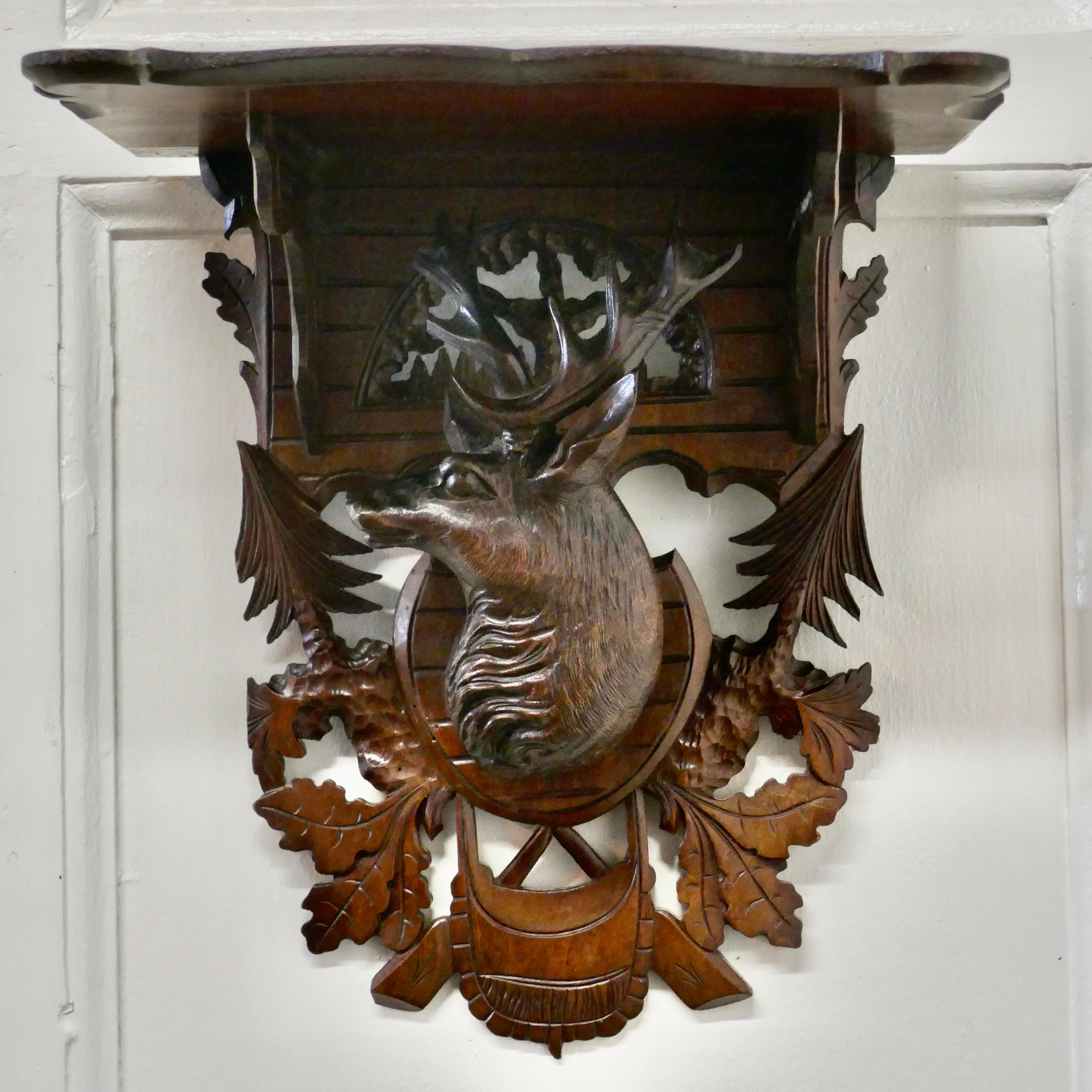 Black Forest style carved wall bracket shelf 

This is a delightful item, the bracket has a carved stag’s head decorated with leaves and trees from the forest supporting the shaped bracket shelf
Measures: It is 14” tall, 12” wide and 7”