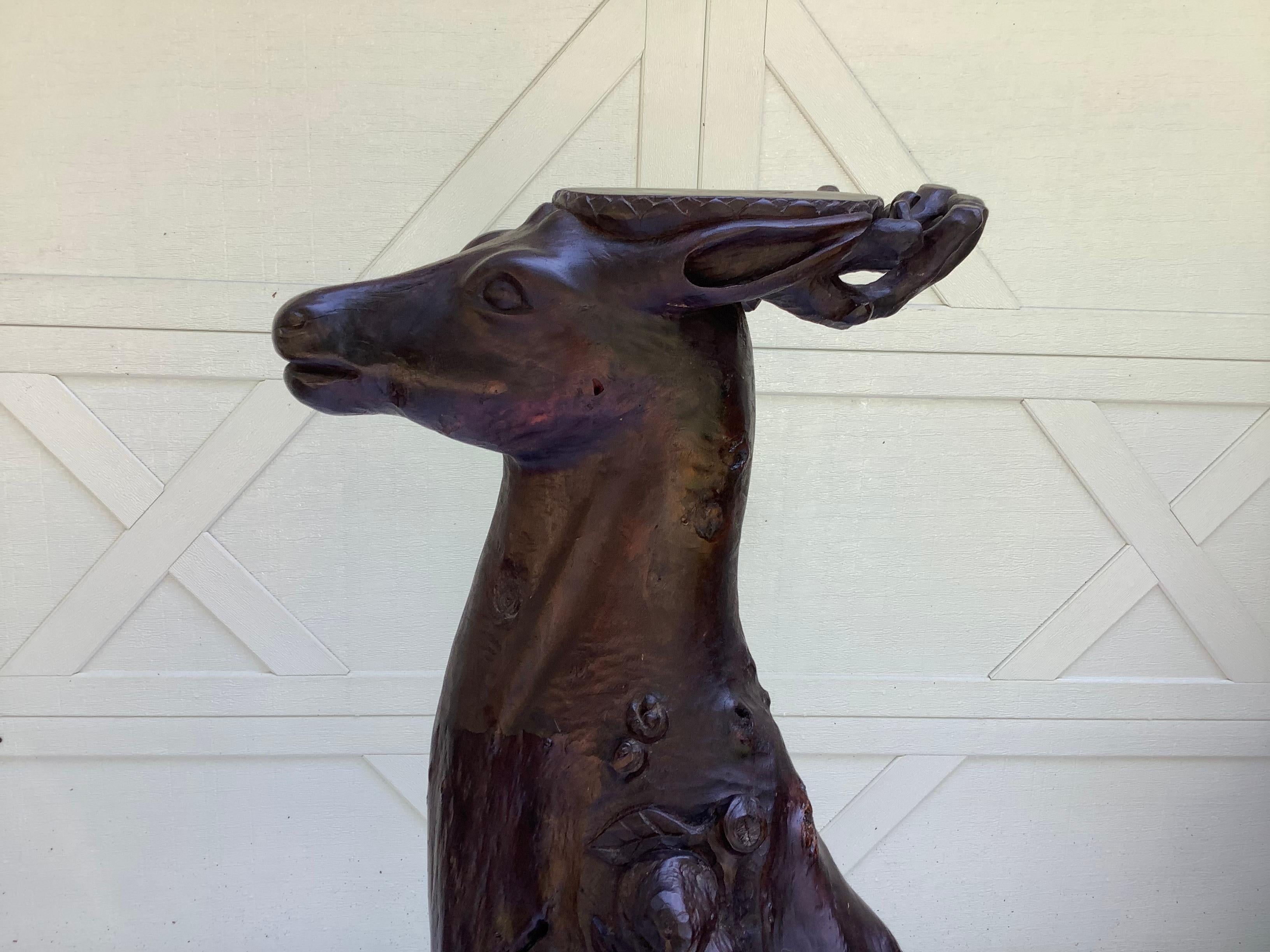 I don’t know a lot about this piece, except that it is very unique. It is a hand carved pedestal, made out of a cypress type wood, with a deer head top. Clearly for displaying, but looks striking, without anything on it. Unsigned. Bought at a Fla.