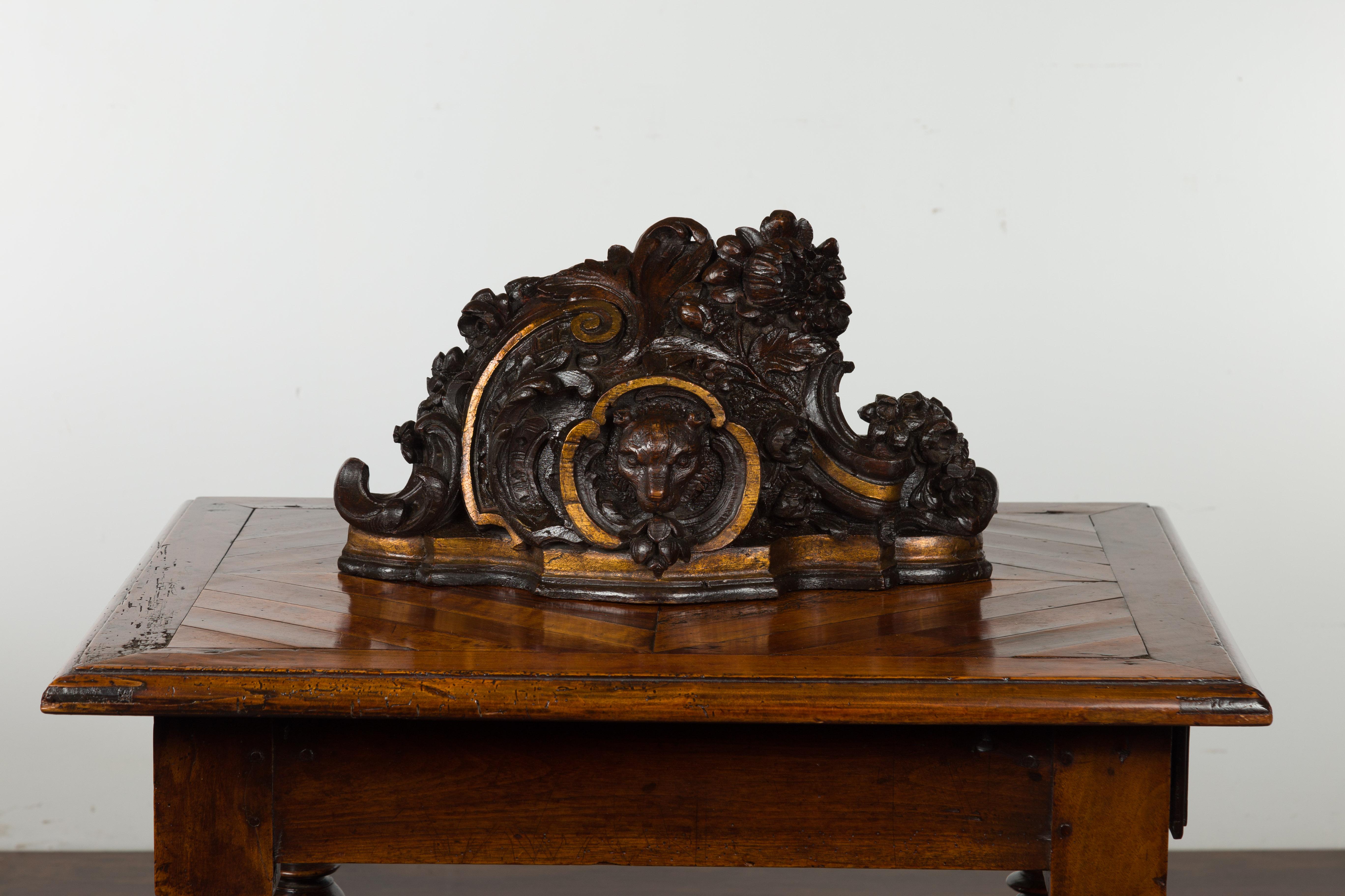 A Black Forest period carved wooden fragment from the early 20th century, with bear motif. hand carved in Switzerland during the turn of the century, this wooden fragment features a bear head in a scrolling cartouche, surrounded by delicate flowers