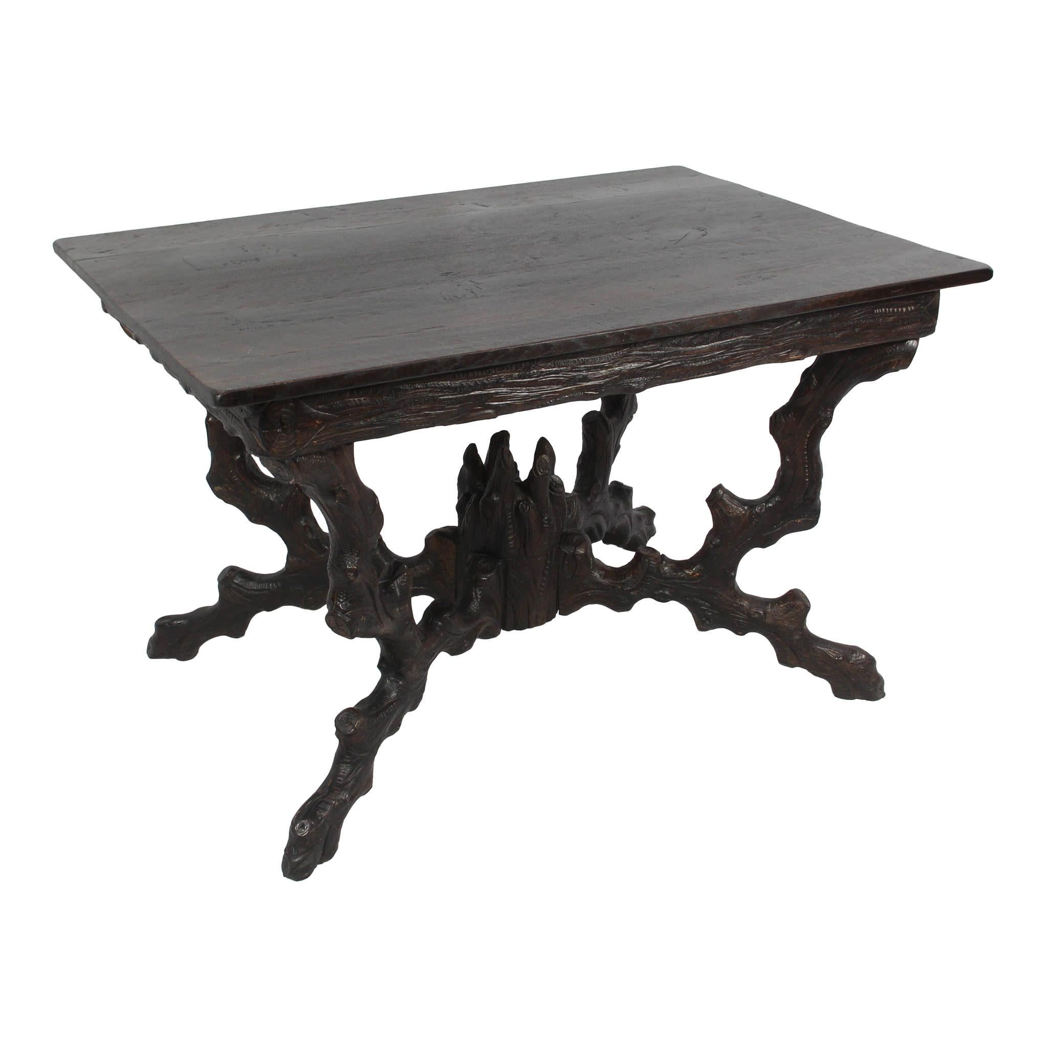 Carved to look like a tree with branches forming the legs and feet extending from a carved trunk, this rectangular table features a rich, dark stain. The chairs show striking contrast both in color and material. The cream color, velvet upholstery of