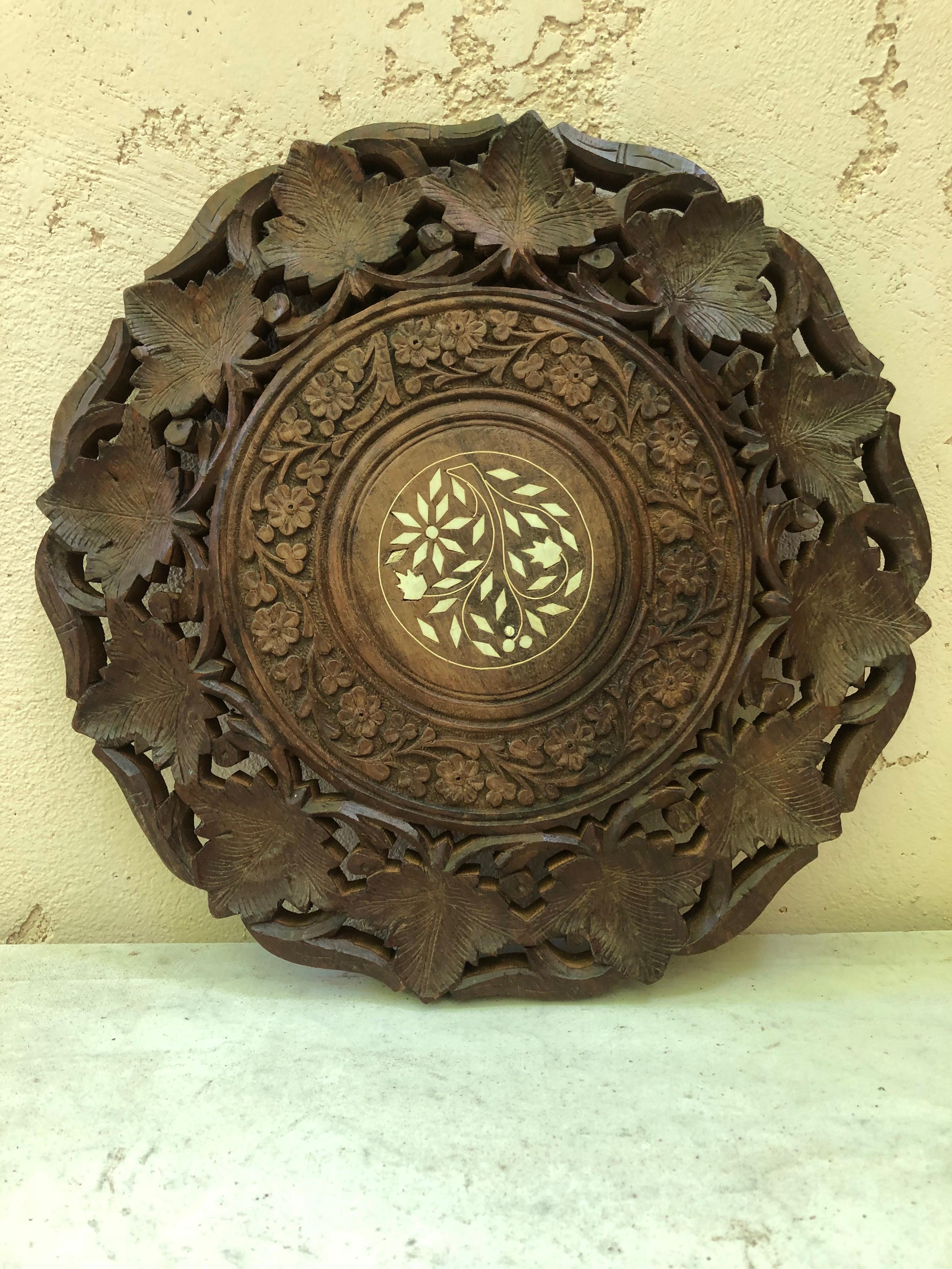 Black Forest trivet carved with leaves, circa 1880.
On the center inlay Marquetry.