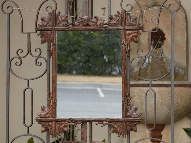 A Swiss Black Forest mirror from the early 20th century, with hand-carved oak leaves and viola motif. Created in Switzerland during the Turn of the Century, this Black Forest mirror attracts our attention with its hand-carved framed adorned with