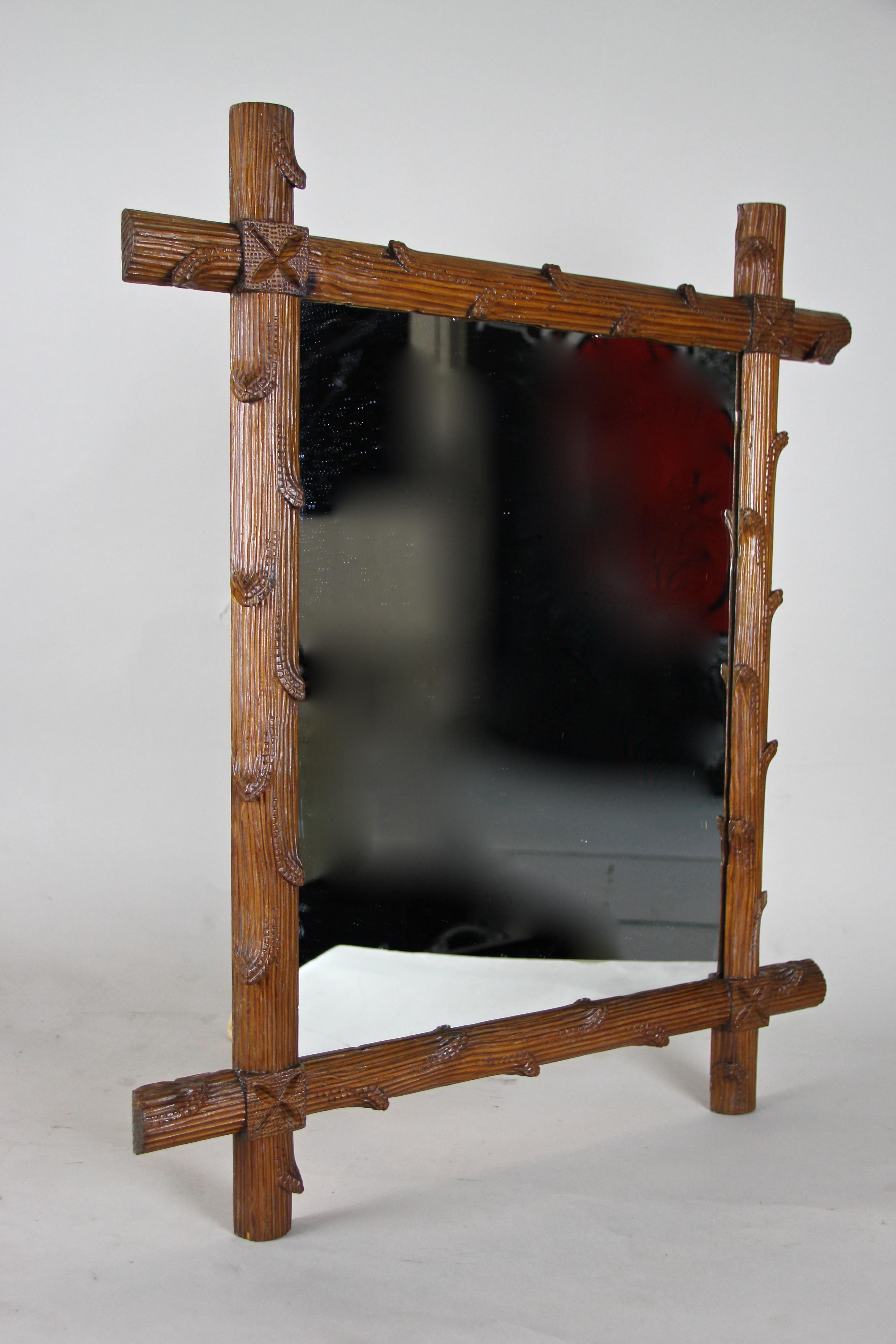 Fantastic hand carved mirror from Austria, circa 1870. This rustic black forest wall mirror has been effortfully hand carved out of basswood in the manner of tree branches showing a light-brown surface, sealed by a light shellac finish. The mirror