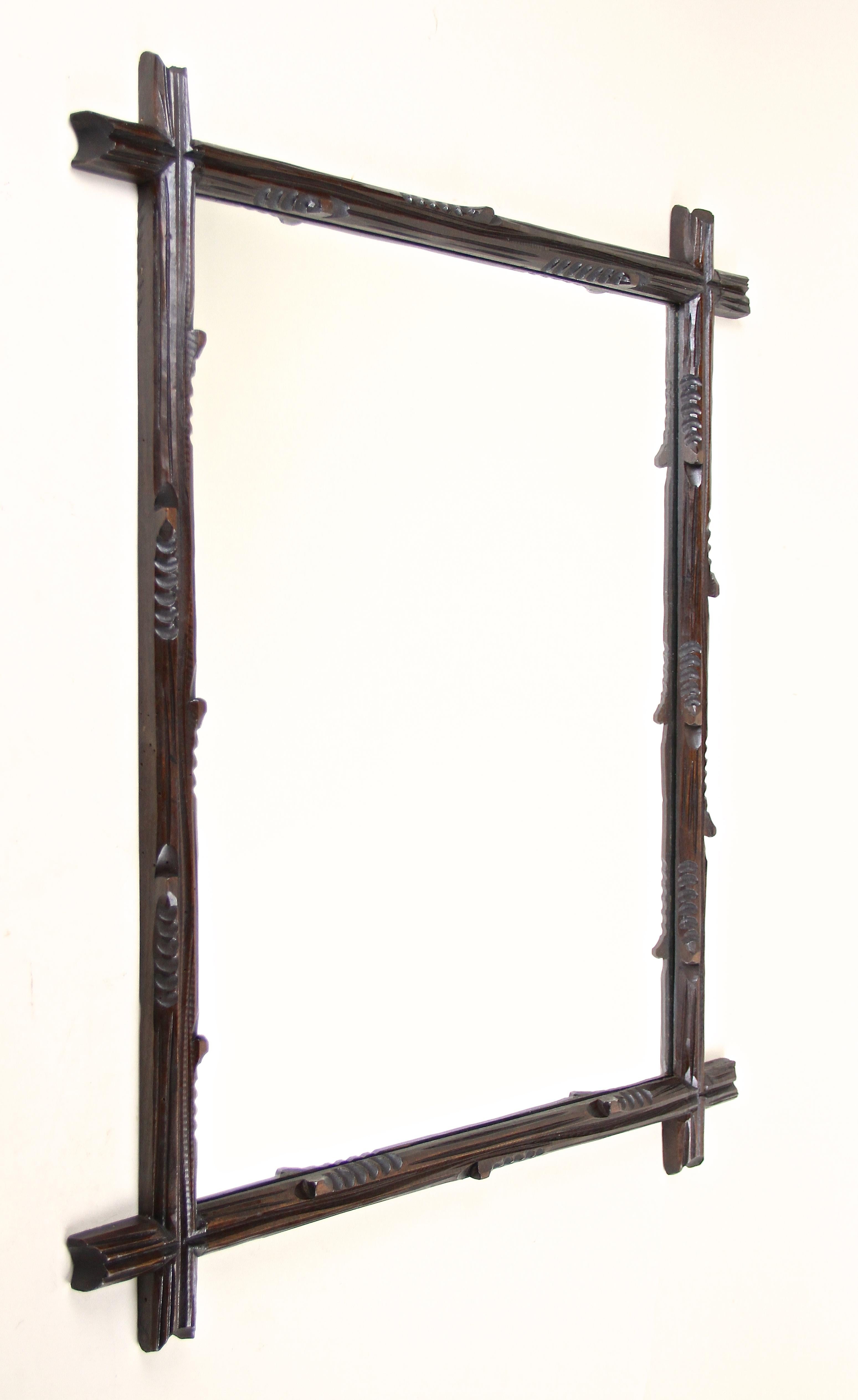 Very decorative rural Black Forest wall mirror from the late 19th century from circa 1890 in Austria. The beautiful hand carved frame impresses with an unusual 