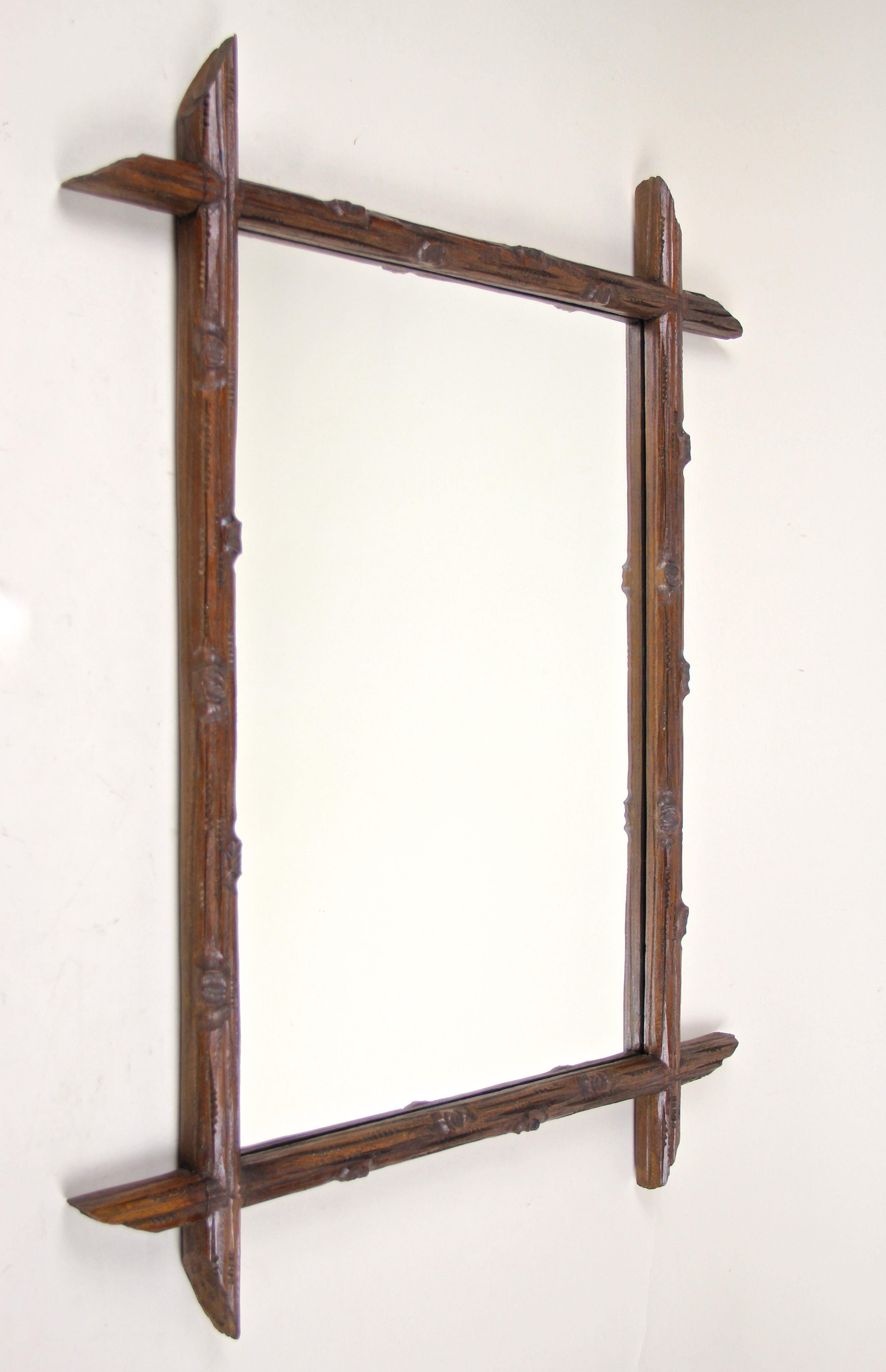 Rustic Black Forest wall mirror from Austria, circa 1880. This lovely antique wall mirror impresses with a simple but elegant 