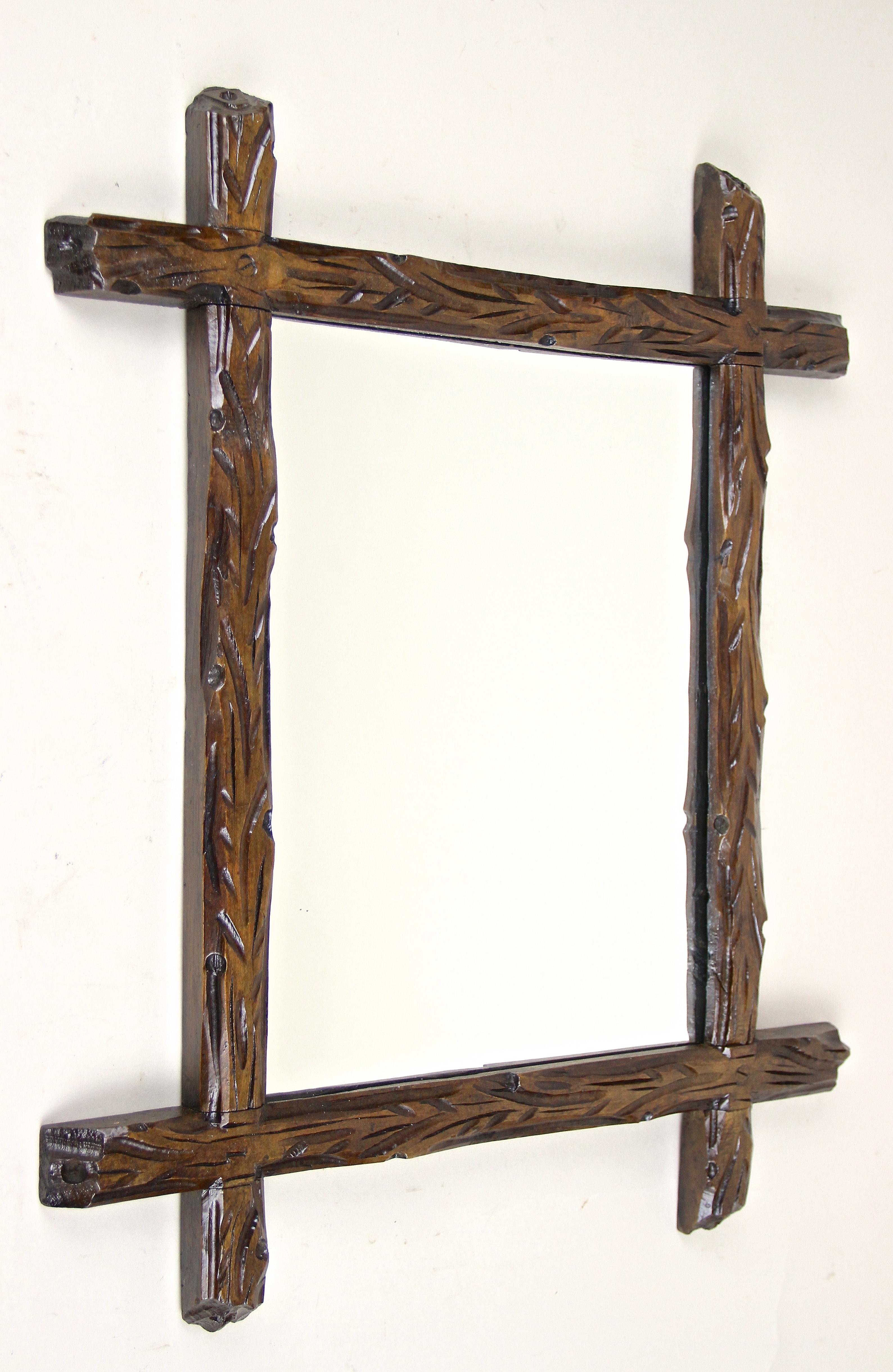 From Austria around 1880 comes this unusual rustic small Black Forest mirror, impressing with its extraordinary old tree trunks design. The artfully hand carved basswood frame with protruding corners conveys a fantastic 