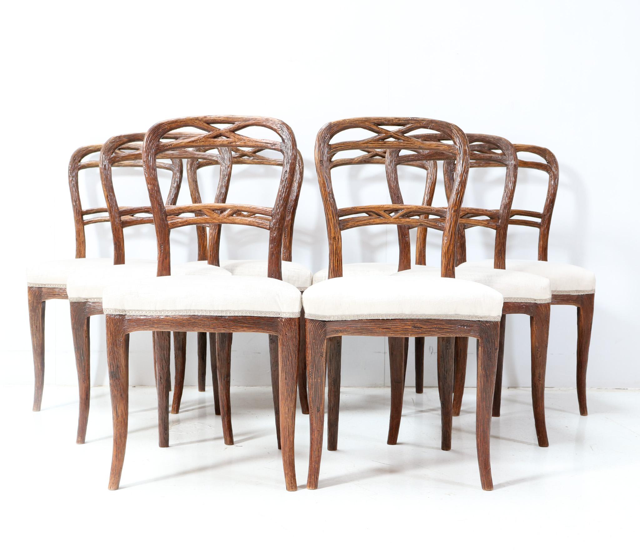 Magnificent and rare set of eight Black Forest dining chairs. Design by Matthijs Horrix for Horrix Den Haag. Striking Dutch design from the 1880s. Solid hand-carved walnut base and re-upholstered with a quality white fabric. This wonderful set of
