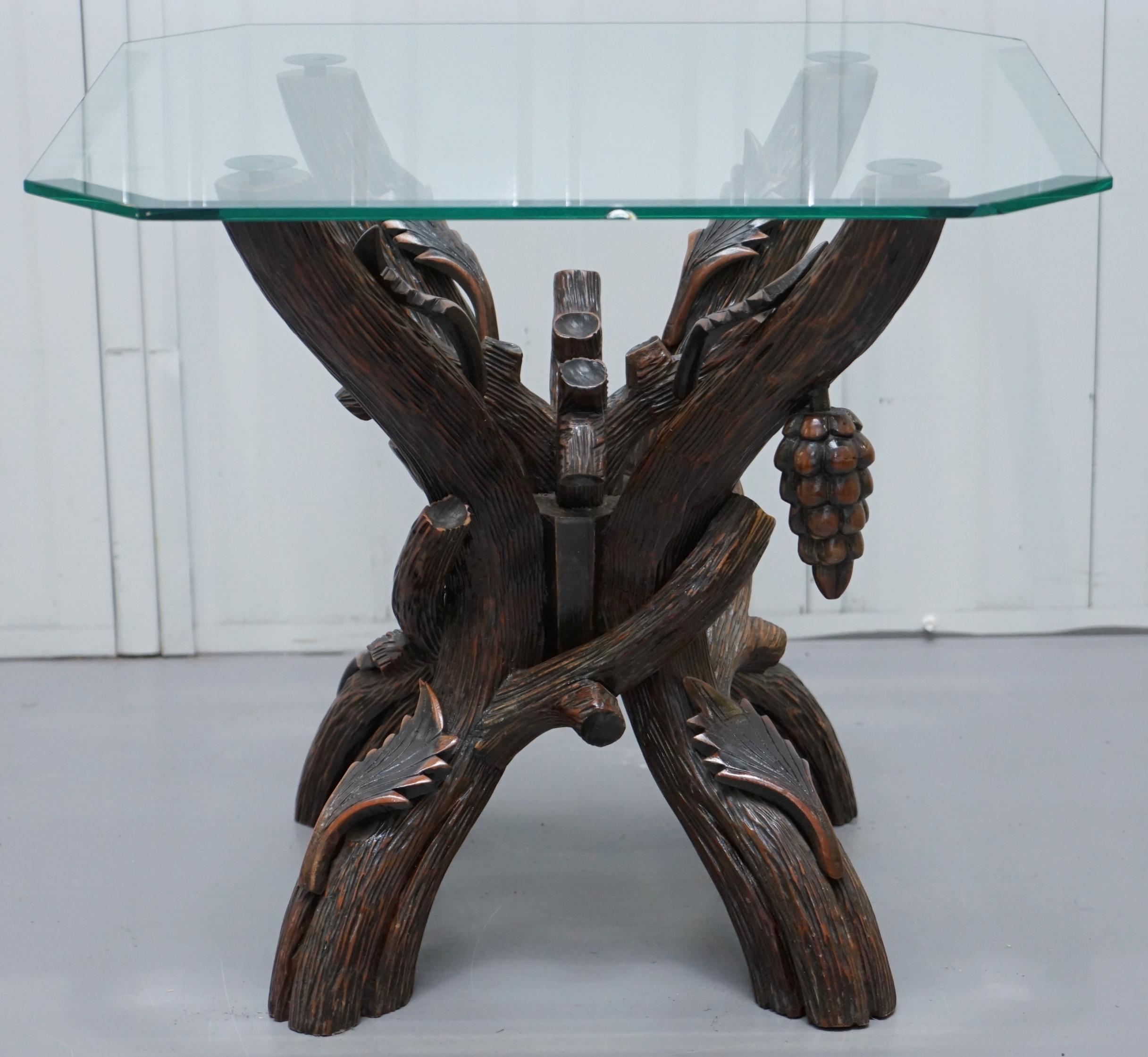 We are delighted to offer for sale this nice vintage black forest wood carved side lamp table with tapered glass top

A good looking and well-made piece, the legs are carved from wood to look like tree trunks, there are leaved and one bunch of