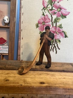 Black Forest wood carving of man blowing a swiss horn
