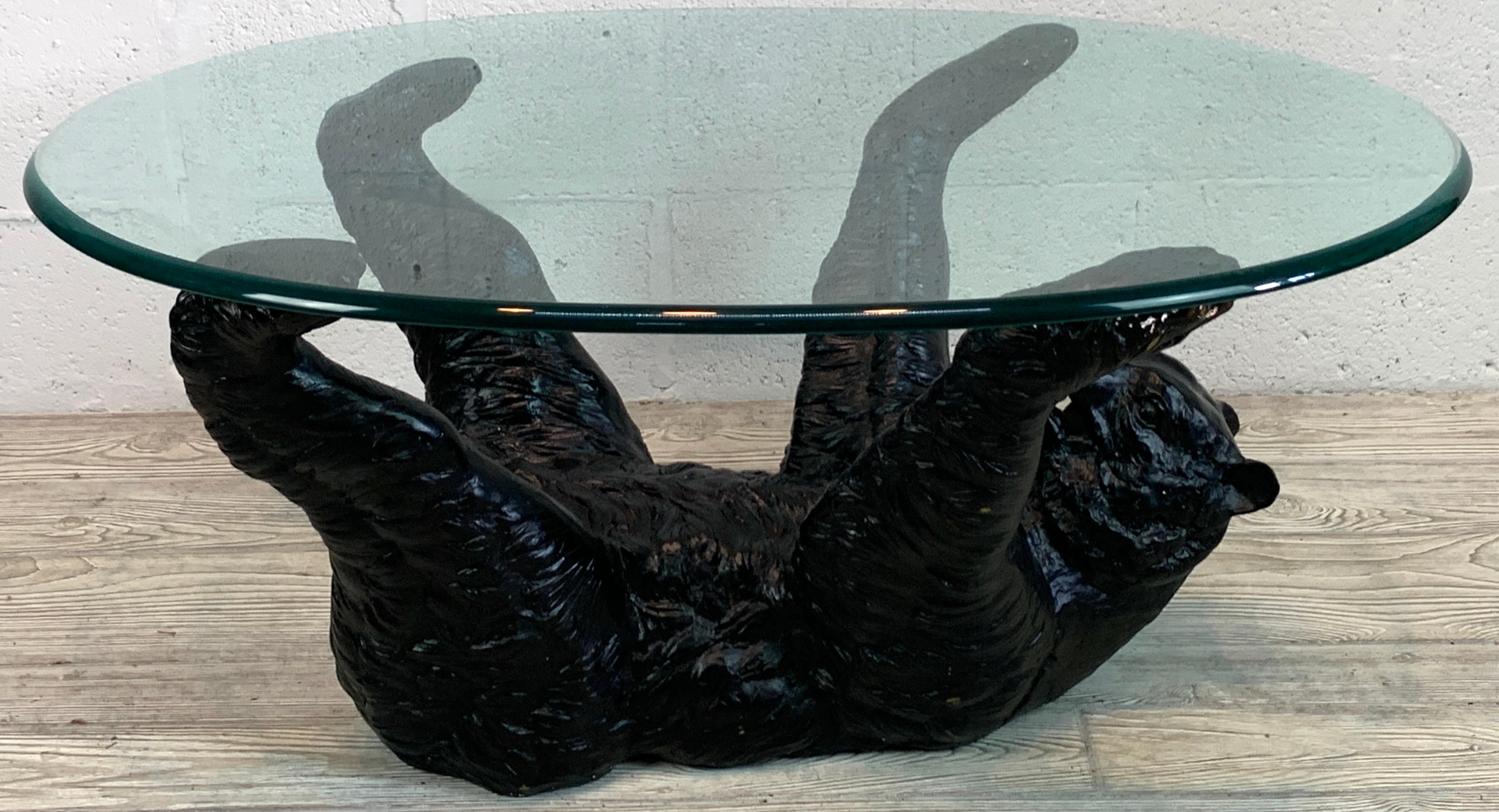 Black Forrest bronze bear coffee table 
Realistically cast and modeled of a bear on his back supporting the oval glass top with his four legs. 
The bear sculpture measures 20