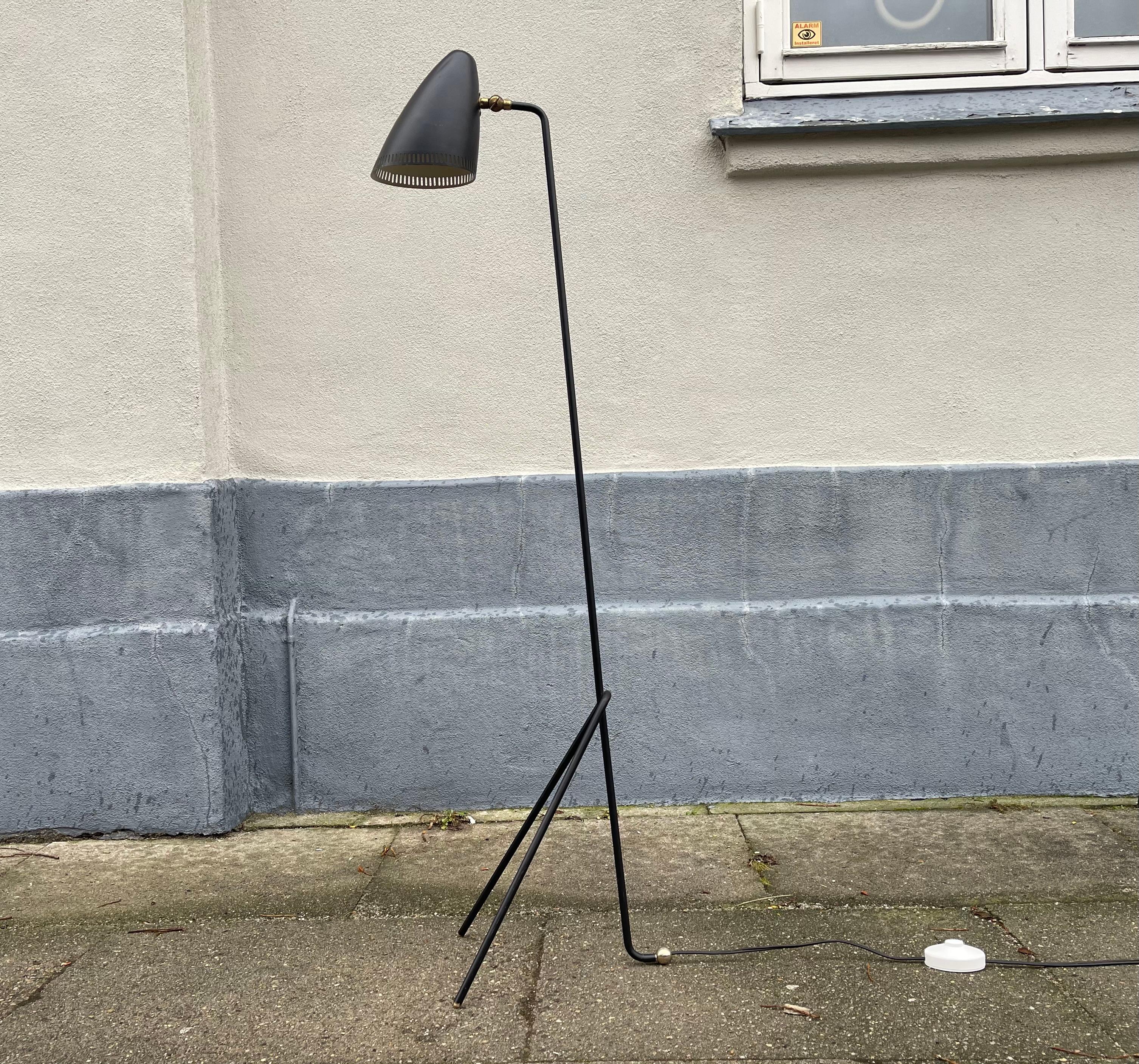A rare configuration of the black Giraffe Floor lamp by Svend Aage Holm-Sørensen. It is light design executed in Lacquered aluminum with brass accent. It features a vertically perforated shade with white reflective interior that's adjustable up/down