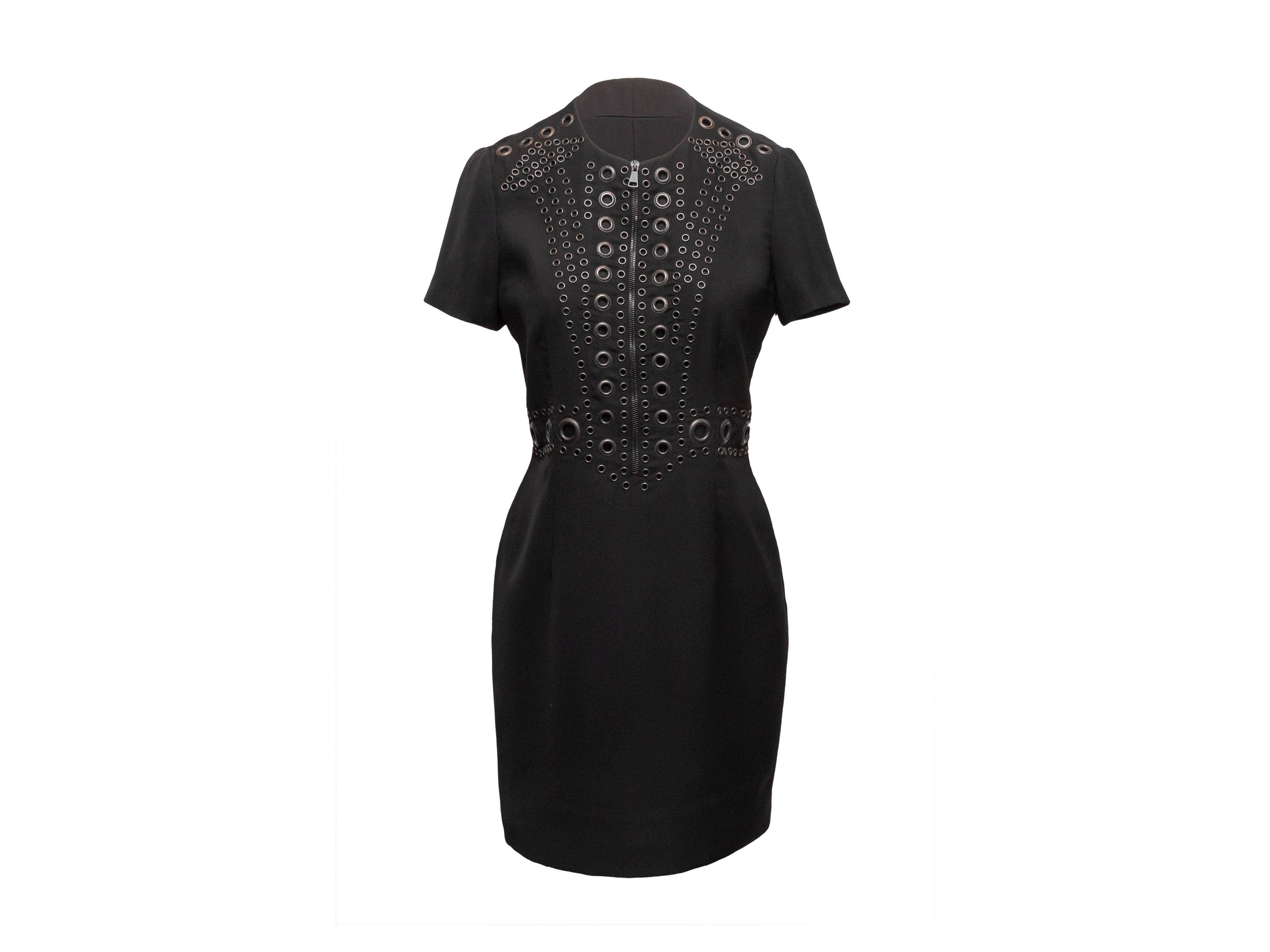 Black short sleeve sheath dress by Givenchy. Grommet embellishments throughout. Crew neck. Zip closure at center front. 32