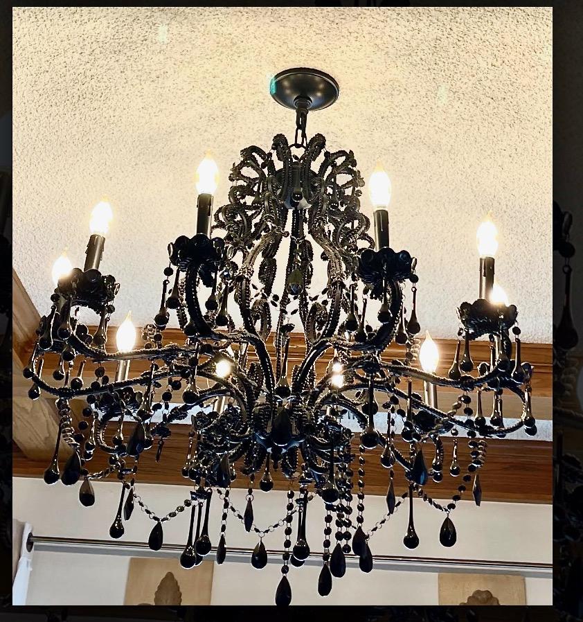 This is an attention grabbing late 20th century black glass chandelier. This large chandelier features 10 candle arms and is in excellent condition, retaining its myriad black glass elements. Black glass chandeliers and the large size of this