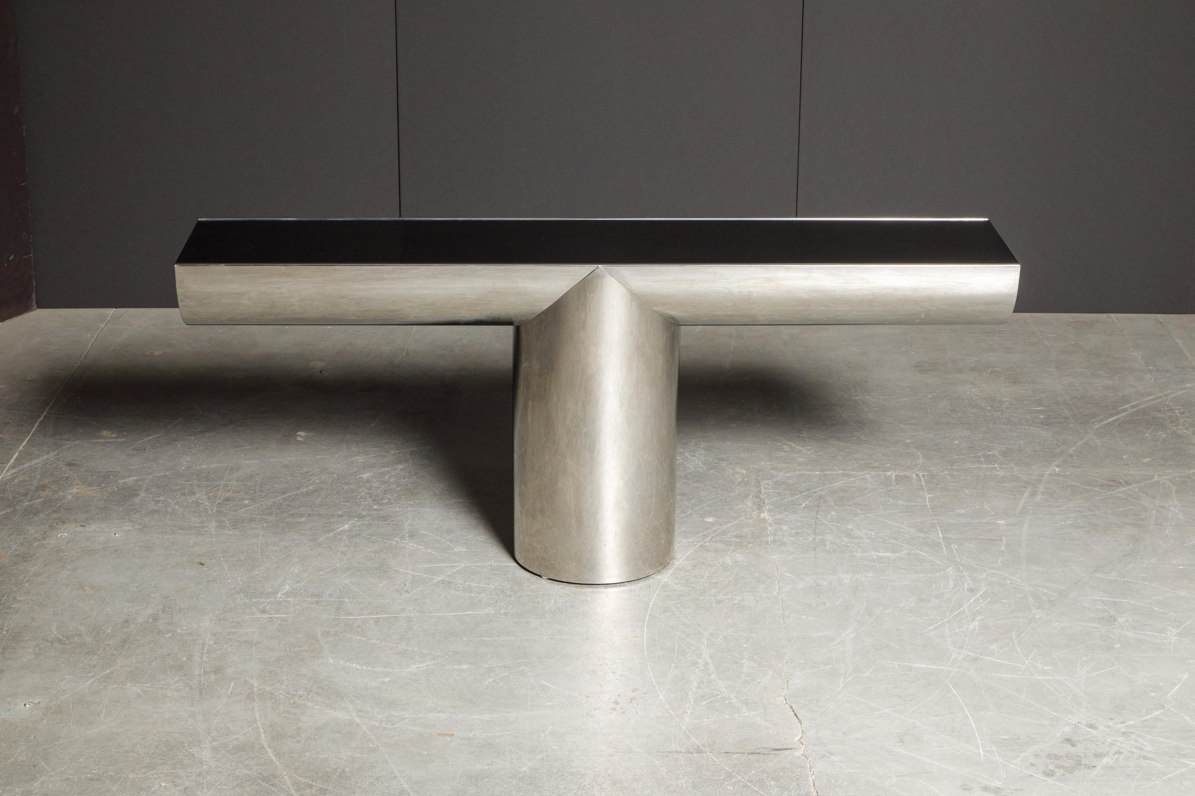 This stylish and classy console table by J. Wade Beam for Brueton features deep black glass and shiny polished stainless steel in the form of a 'T' shape - cantilevering the ends almost like magic. Designed and produced in the 1970's, Brueton's