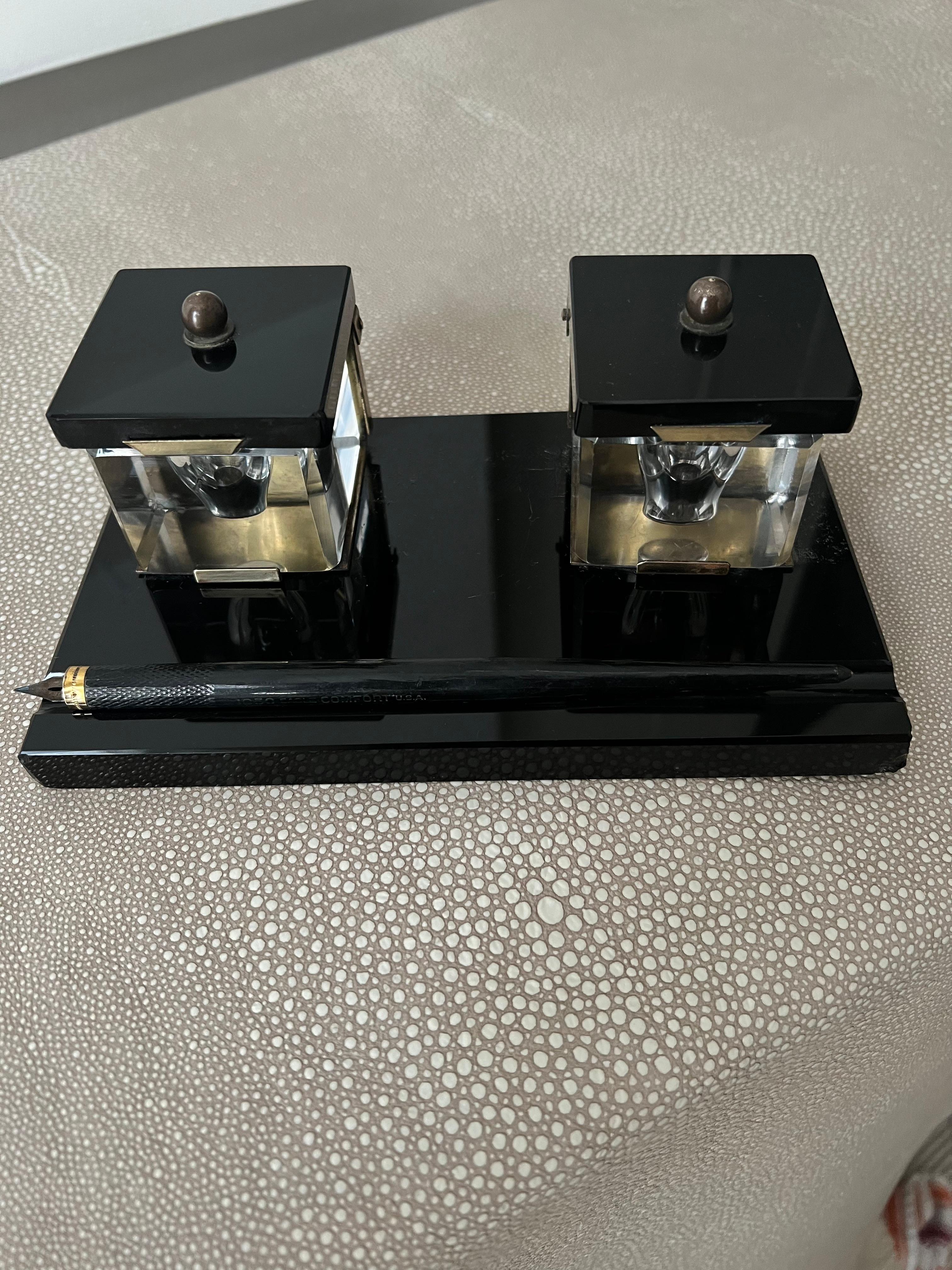 A stunning Black Glass ink well with two lidded Crystal ink wells. The piece is wonderful and in very good condition.  Also rare, both crystal wells are chip free and the piece has the original dipping pen.

The housing is brass and we have left it