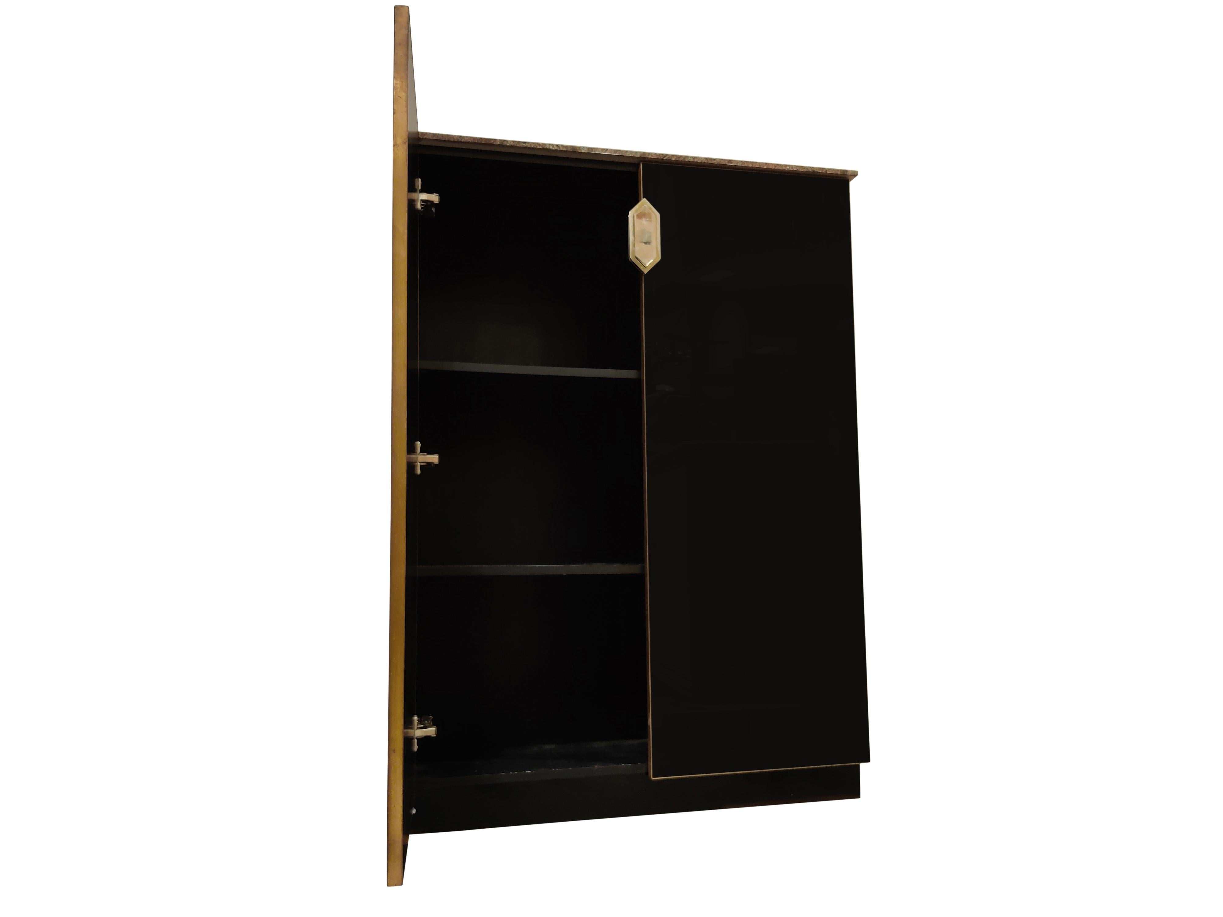 Hollywood Regency black glass and brass bar cabinet with a beautiful granite stone top.

It features 2 doors with a nicely shaped door handle and two shelves - plenty of storage space for glasses and bottles. 

This pieces gives a great touch of