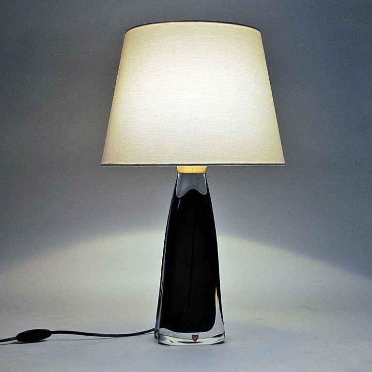 Lovely mid-century black glass table lamp model RD1323 designed by Carl Fagerlund for Orrefors Glass, Sweden 1960s. Inner black crystal glass core surrounded by a clear glass cover. Brass details on top. The lamp are heavy with elegante shape and