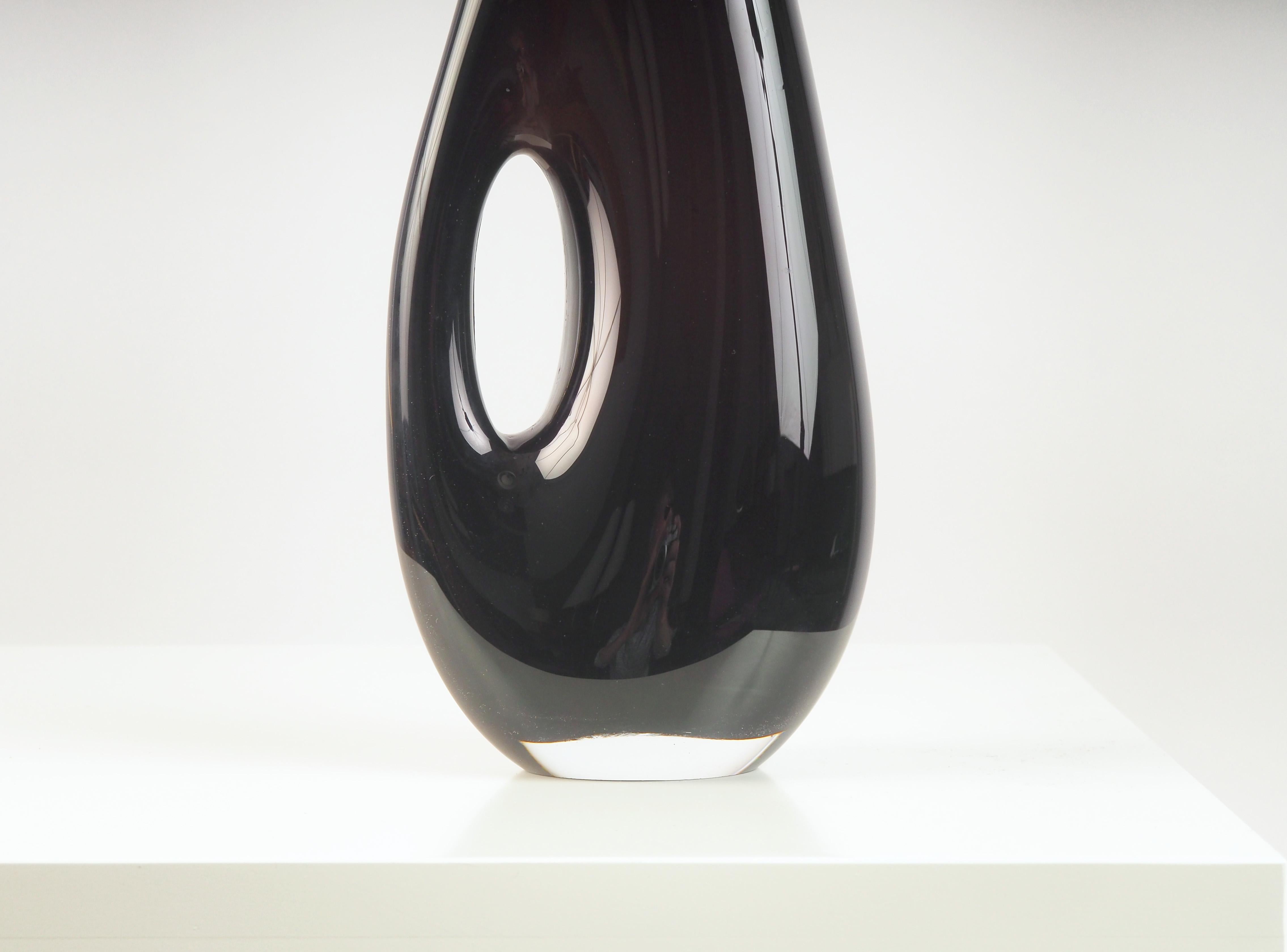Rare black vase by Vicke Lindstrand made at Kosta Glasbruk during the 1950s. The vase is made in sommerso technique with a large asymmetric hole through the body of the vase.