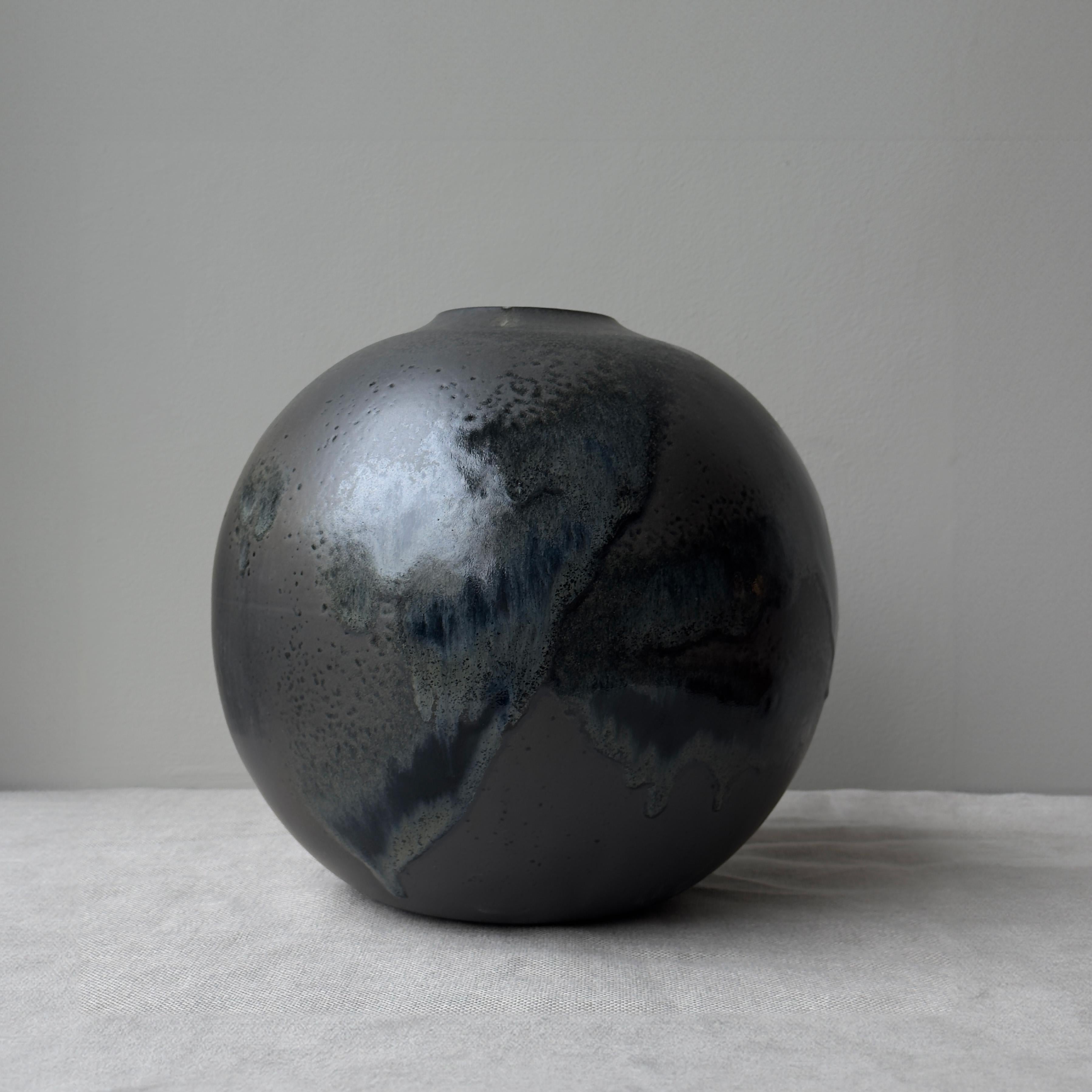 A black, globe-shaped vase designed and made in Denmark by K H Würtz. 

This vessel by K H Wurtz is almost entirely spherical. The slight foot grounds its monumental stature and its delicate lip imbues the vessel with a quiet elegance.This piece is
