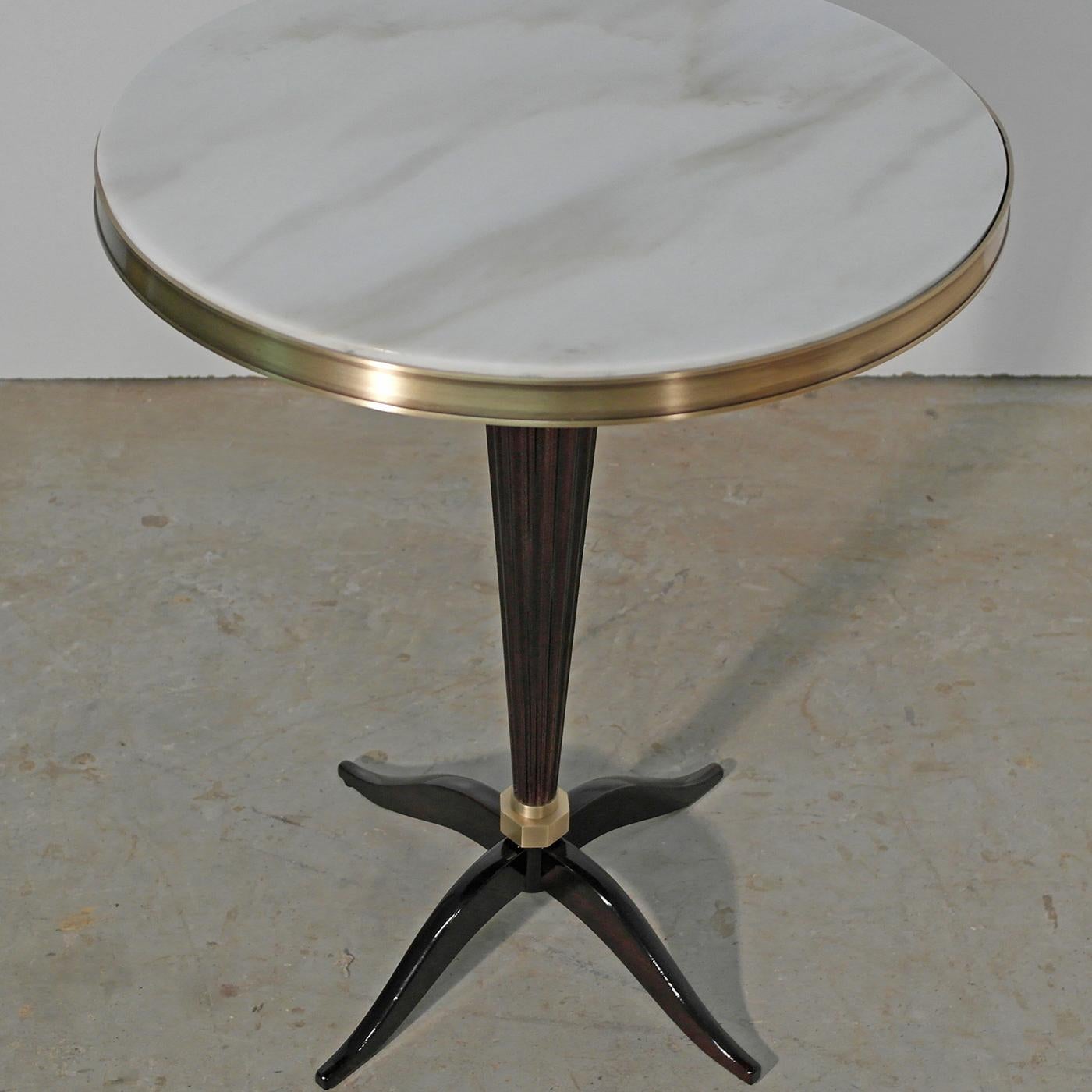 This round side table is crafted from solid wood. Its glossy rosewood-stained finish brings a warm feel to any room, enhanced with brass accents with a brushed bronze finish. Finished with a Calacatta marble top, the black gloss round side table