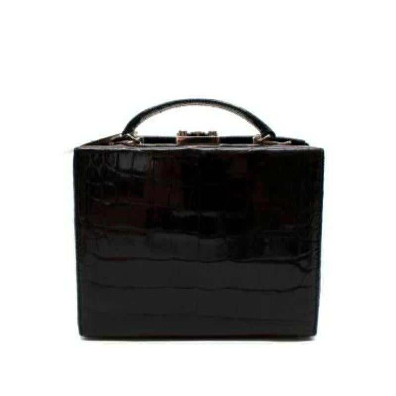 Mark Cross Black Glossy Crocodile Grace Box Bag
 
 - Medium sized iconic Grace bag, inspired by Grace Kelly in Rear Window
 - Glossy Crocodile skin outer
 - Silver-tone brass hardware
 - Signature red nappa leather lining
 - Two different sized,