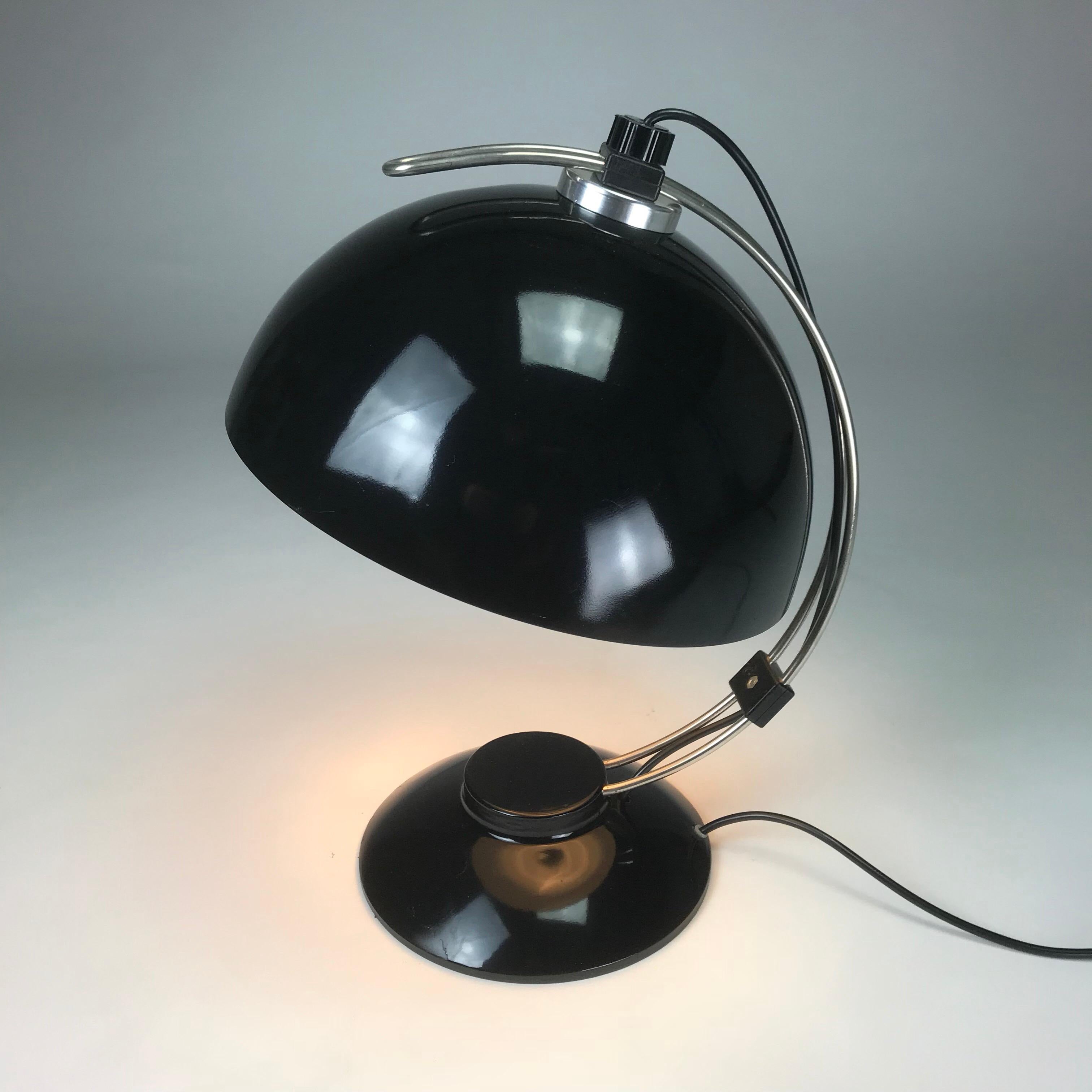 Beautiful high gloss black table lamp from the 1970s. 

The light consists of a heavy black lacquered base with curved chrome tube stem and a white/black lacquered shade. 

The shade can be adjusted by sliding it along the curved stem and