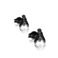 Black gold earrings featuring a symbolic fly motif