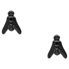 Black gold earrings featuring a symbolic fly motif