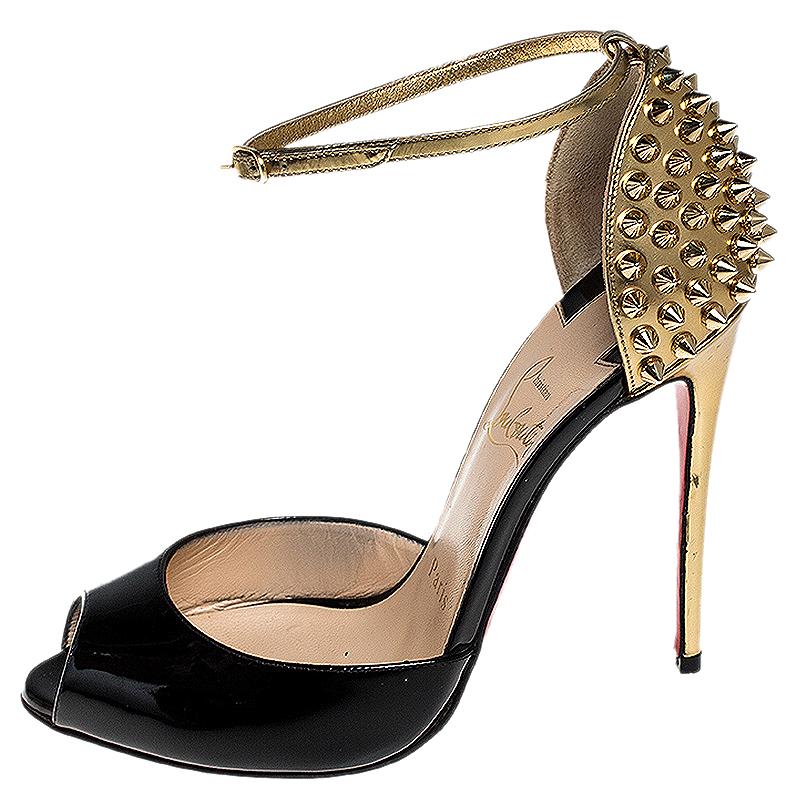 These dream-like sandals from Christian Louboutin feature black patent leather uppers, peep toes and gold patent leather counters decorated with spikes. They come with adjustable ankle straps and 11.5 cm long heels with the signature red