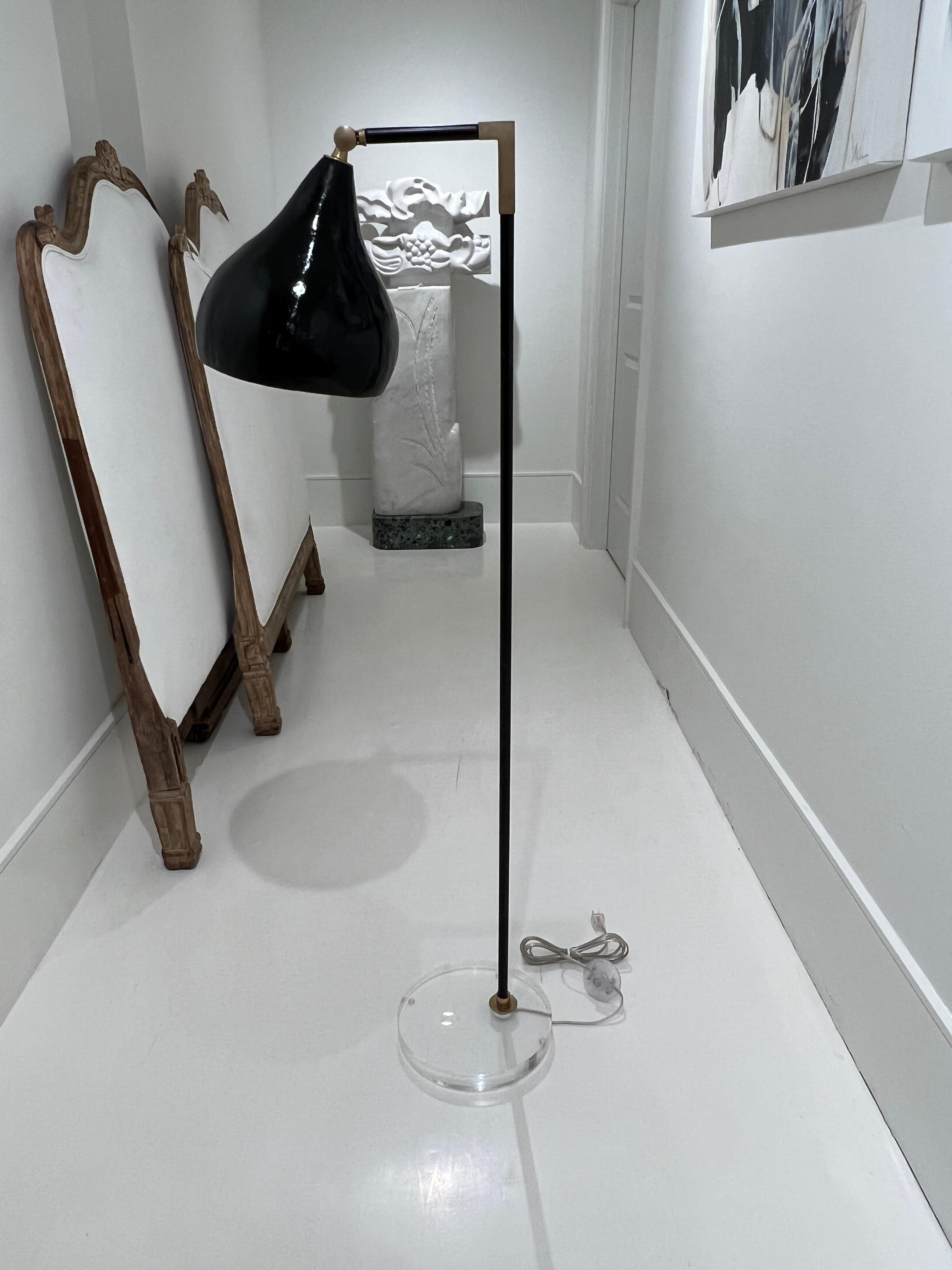 Floor lamp made from a gourd. It is varnished with a high gloss back enamel and electrified. The gourd is mounted on a metal and brass adjustable pole and the base is clear acrylic.