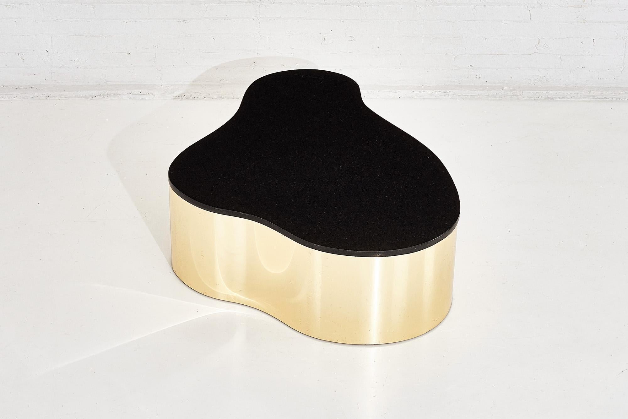 Black granite and brass biomorphic coffee table in style of Karl Springer, circa 1980s.