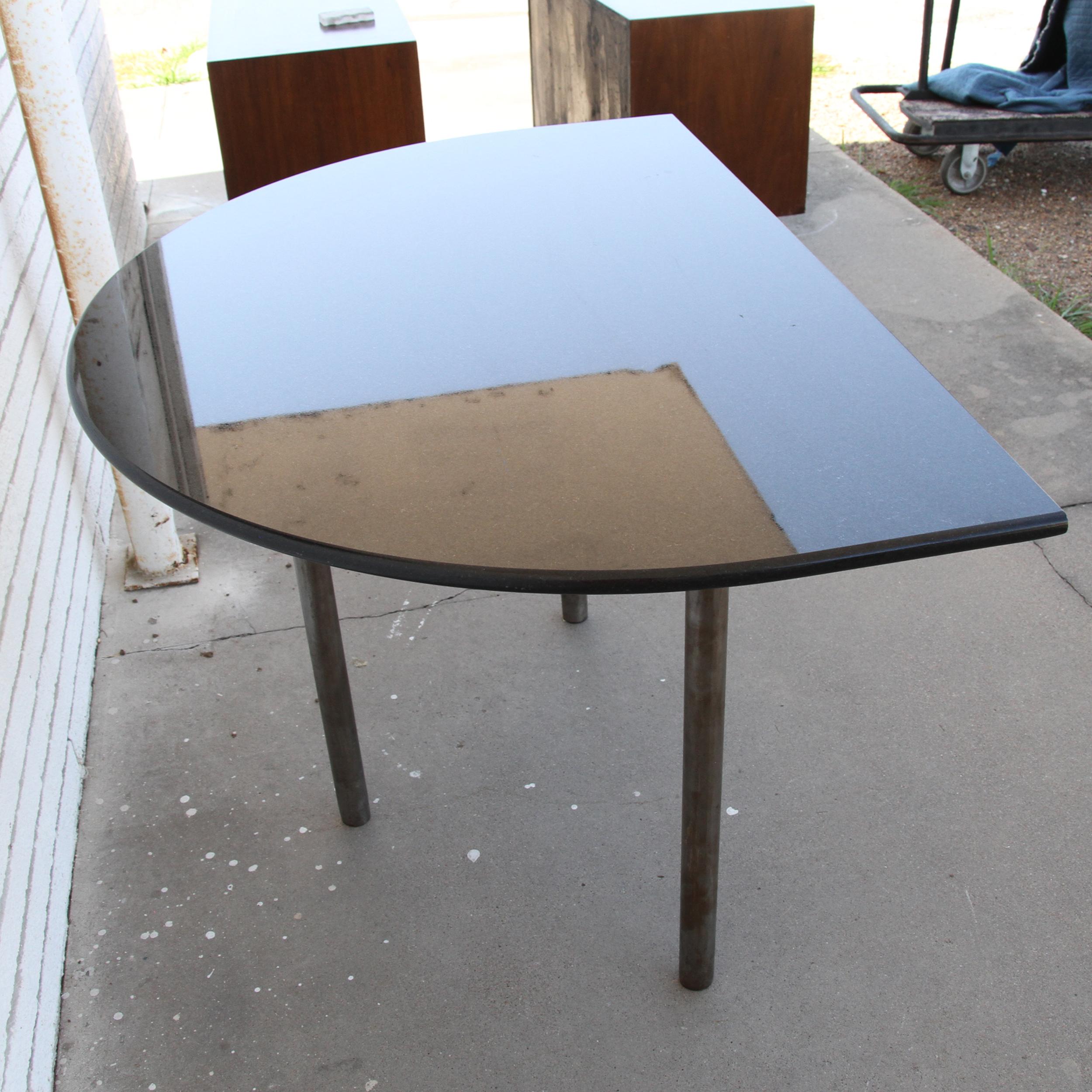Il s'agit d'une magnifique table d'entrée en forme de demilune. Il est doté d'un magnifique plateau en granit noir et de pieds en acier brossé. 