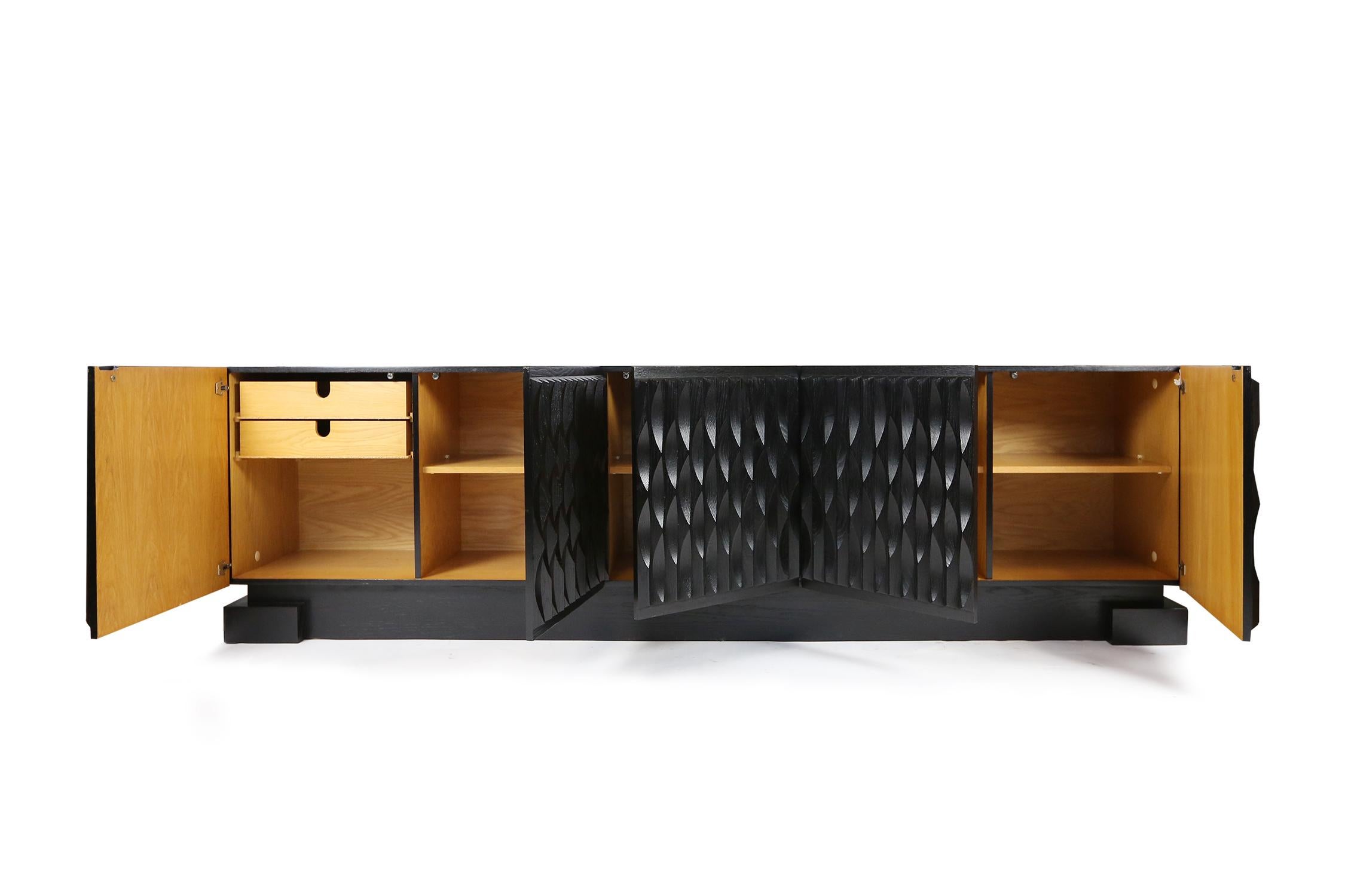 Credenza brutalista in rovere ebanizzato con dettaglio grafico a onda sulle cinque ante anteriori. 
Questo modello in rovere nero ebanizzato ha 5 ante e un ampio spazio di archiviazione. La parte sinistra della credenza ha 2 cassetti in legno di