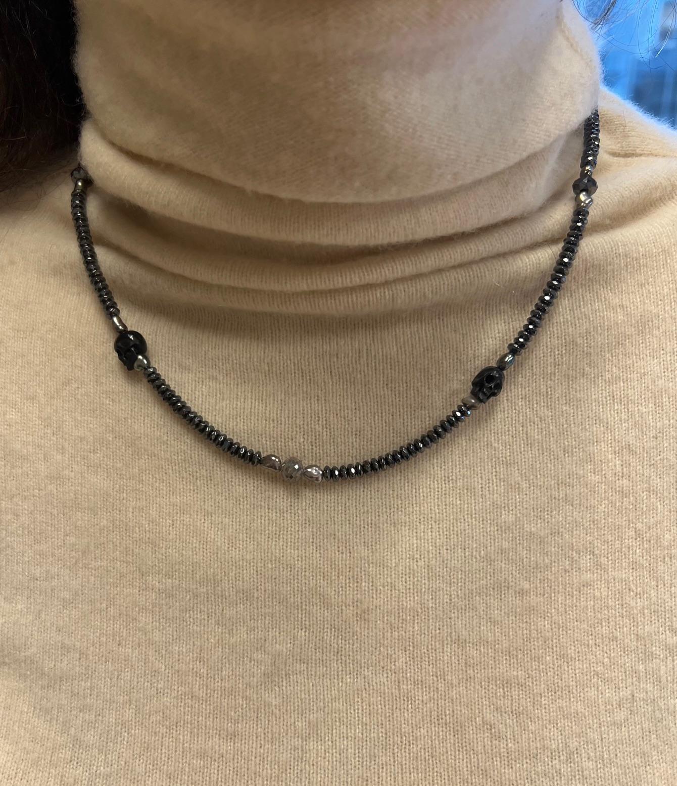 Questa collana da 21 pollici, audace e tagliente, è una fusione sorprendente di raffinatezza e misticismo. Caratterizzato da eleganti perle di ematite, luminose perle di keshi e teschi di osso nero intricatamente intagliati, emana un perfetto