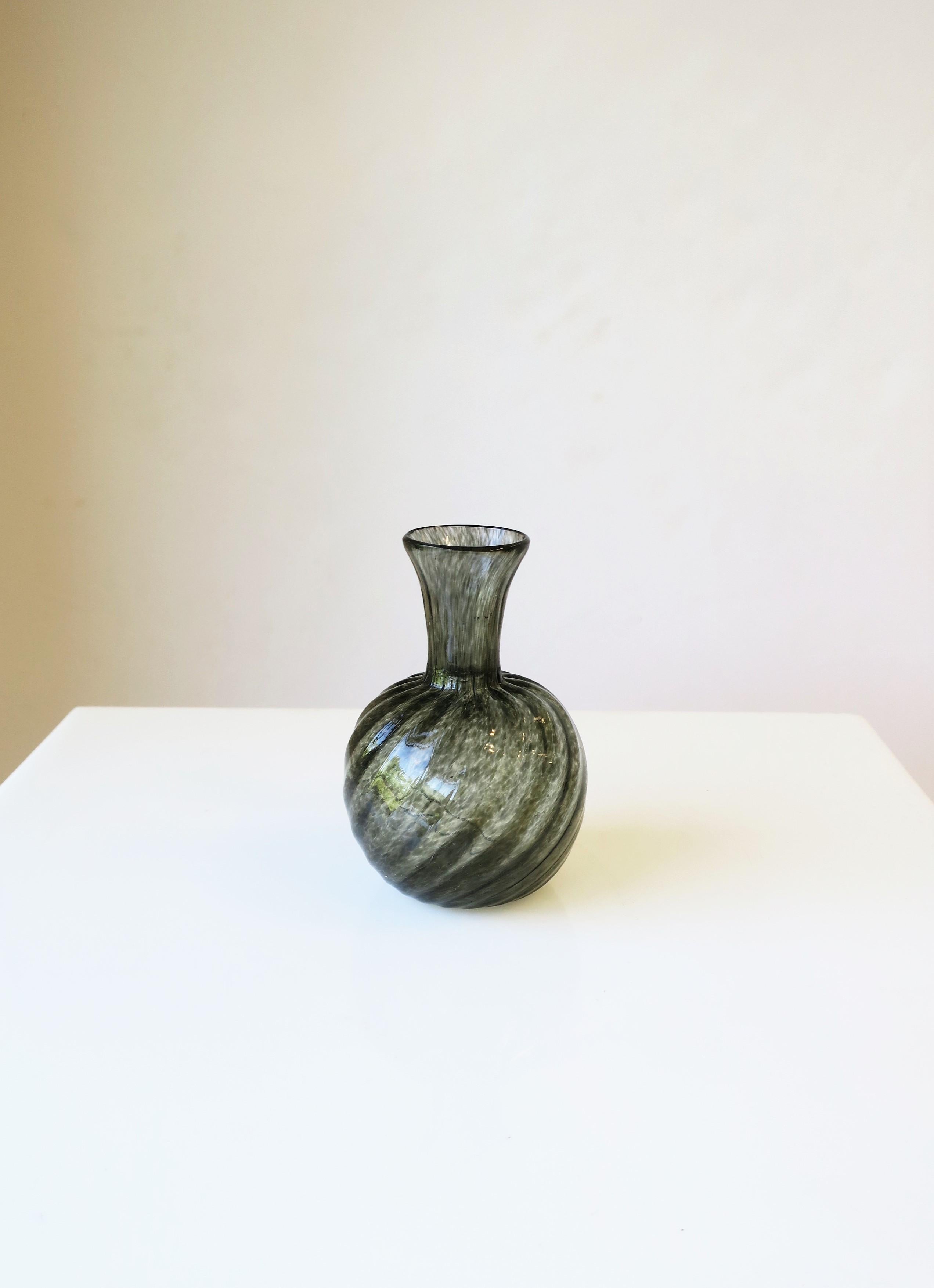 A small black-grey art glass vase with a twisted fluted design, circa late-20th century, Europe. Beautiful as a standalone piece as demonstrated or with a flower or two. Dimensions: 2.75