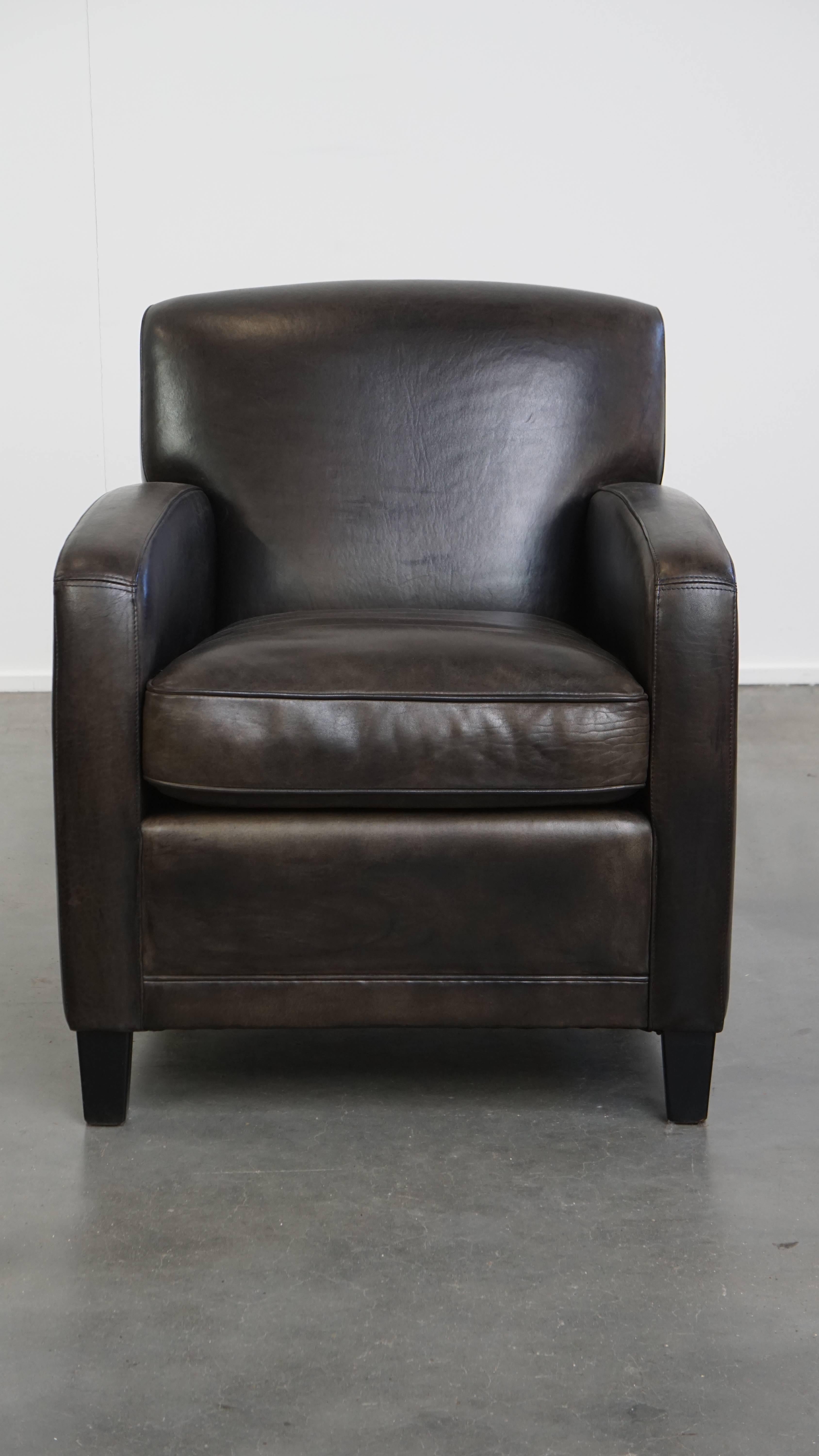 Te presentamos este elegante sillón de diseño en piel de oveja negra/gris con un cómodo asiento. Este sillón negro, fabricado en piel de oveja, tiene un aspecto atemporal y un diseño equilibrado, que le permiten integrarse sin esfuerzo en casi