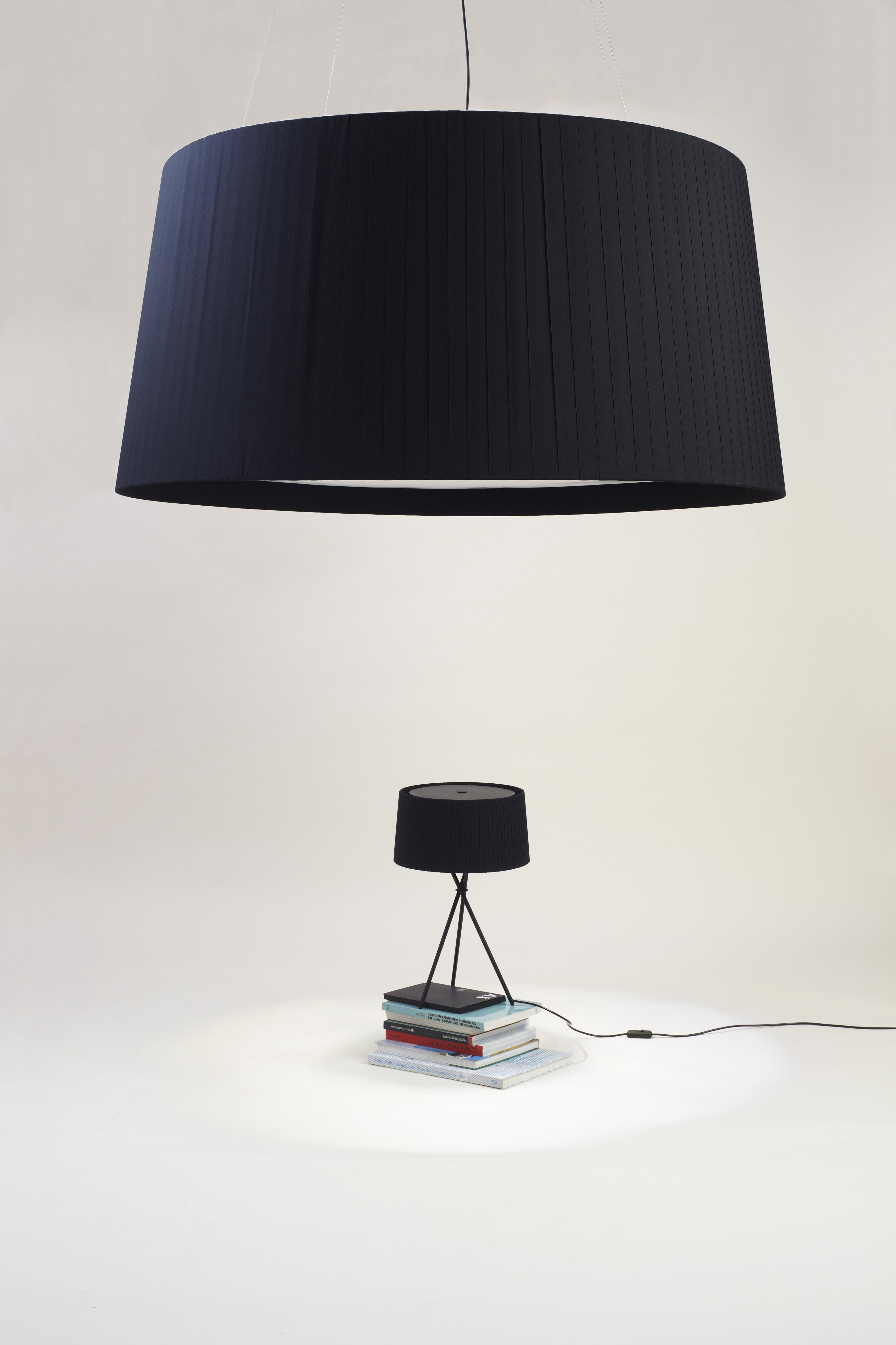 Black GT1500 pendant lamp by Santa & Cole.
Dimensions: D 150 x H 74 cm
Materials: Metal, ribbon.
Available in other colors.

Two lamps with voluminous, beribboned shades, designed for large-scale projects. Both feature a large, translucent disc