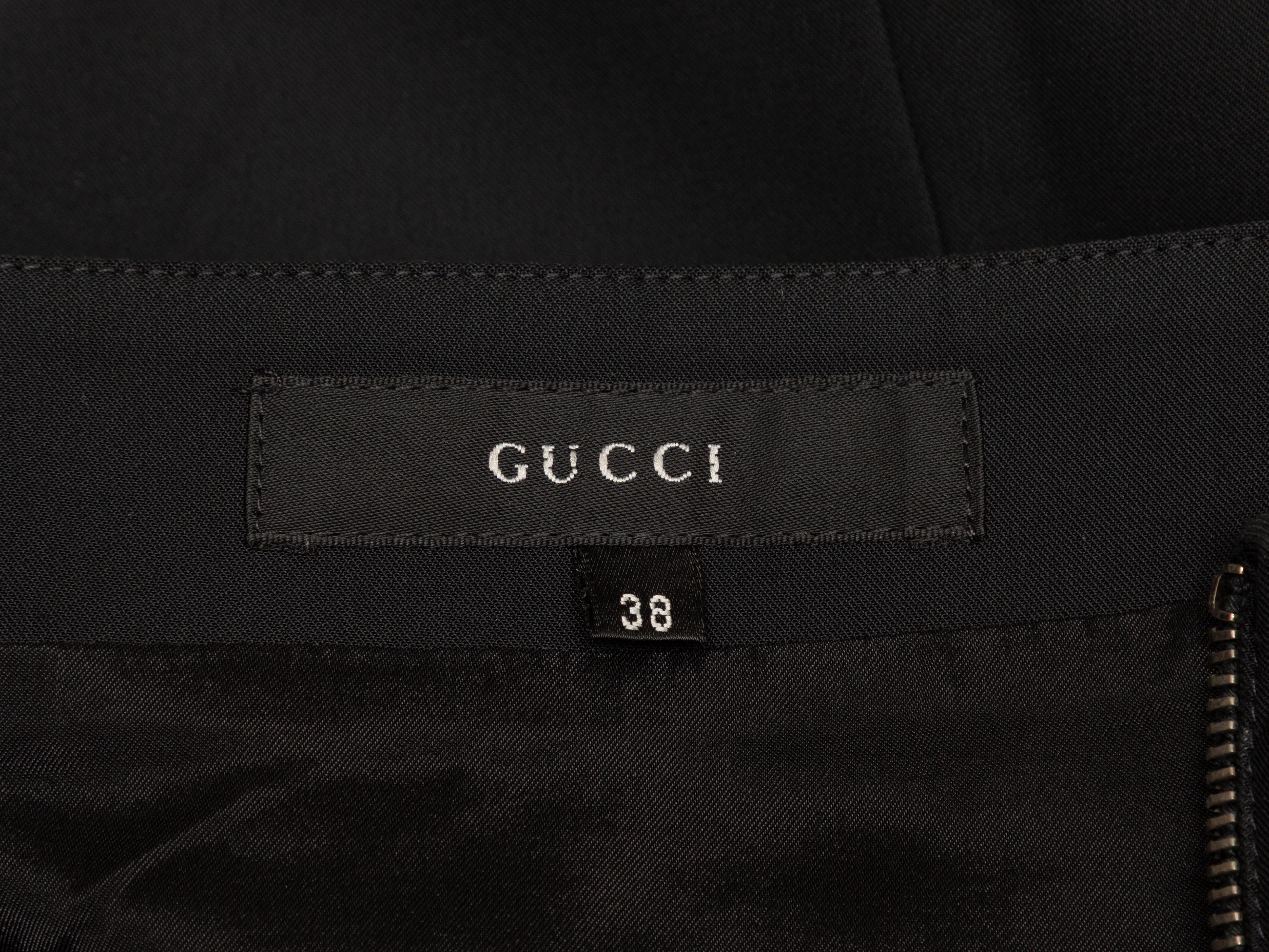 Jupe crayon noire longueur genou de Gucci. Fermeture à glissière apparente sur le devant. Taille 27