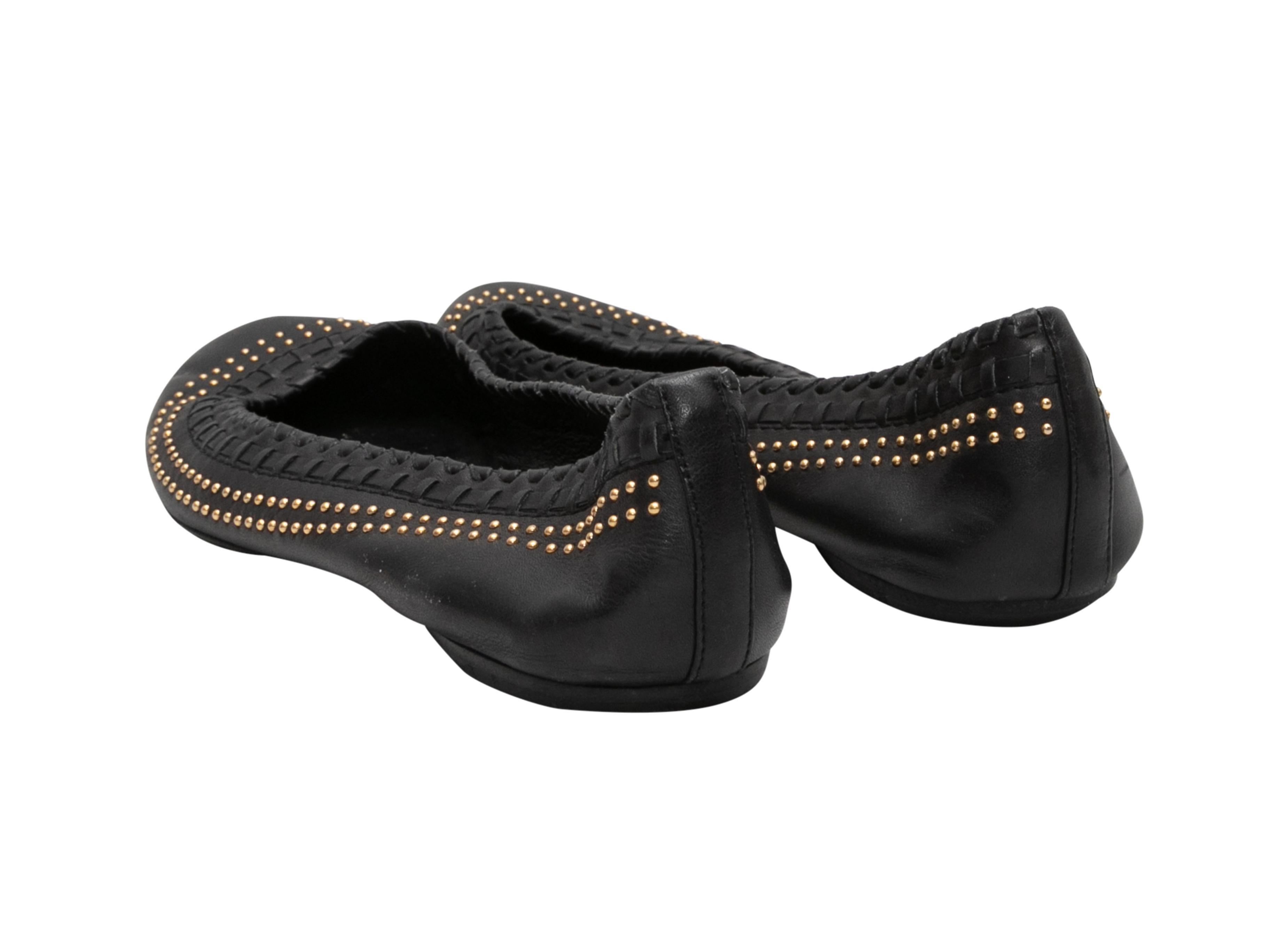 Black leather ballet flats by Gucci. Woven and gold-tone stud detailing at trim.