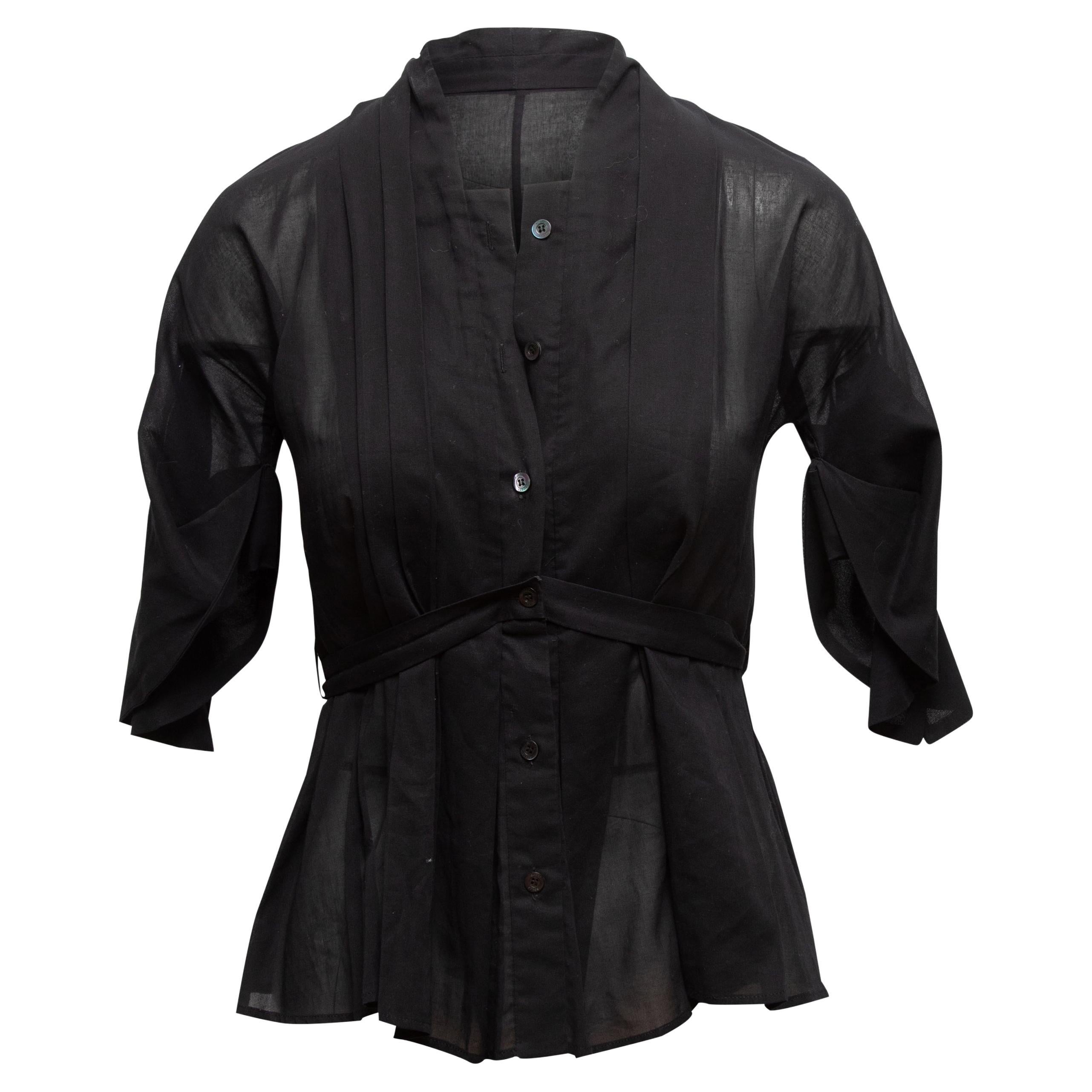 Black cotton three-quarter sleeve button-up top by Gucci. Square neckline. Tie accent at waist. Button closures at center front. Designer size 40. 36