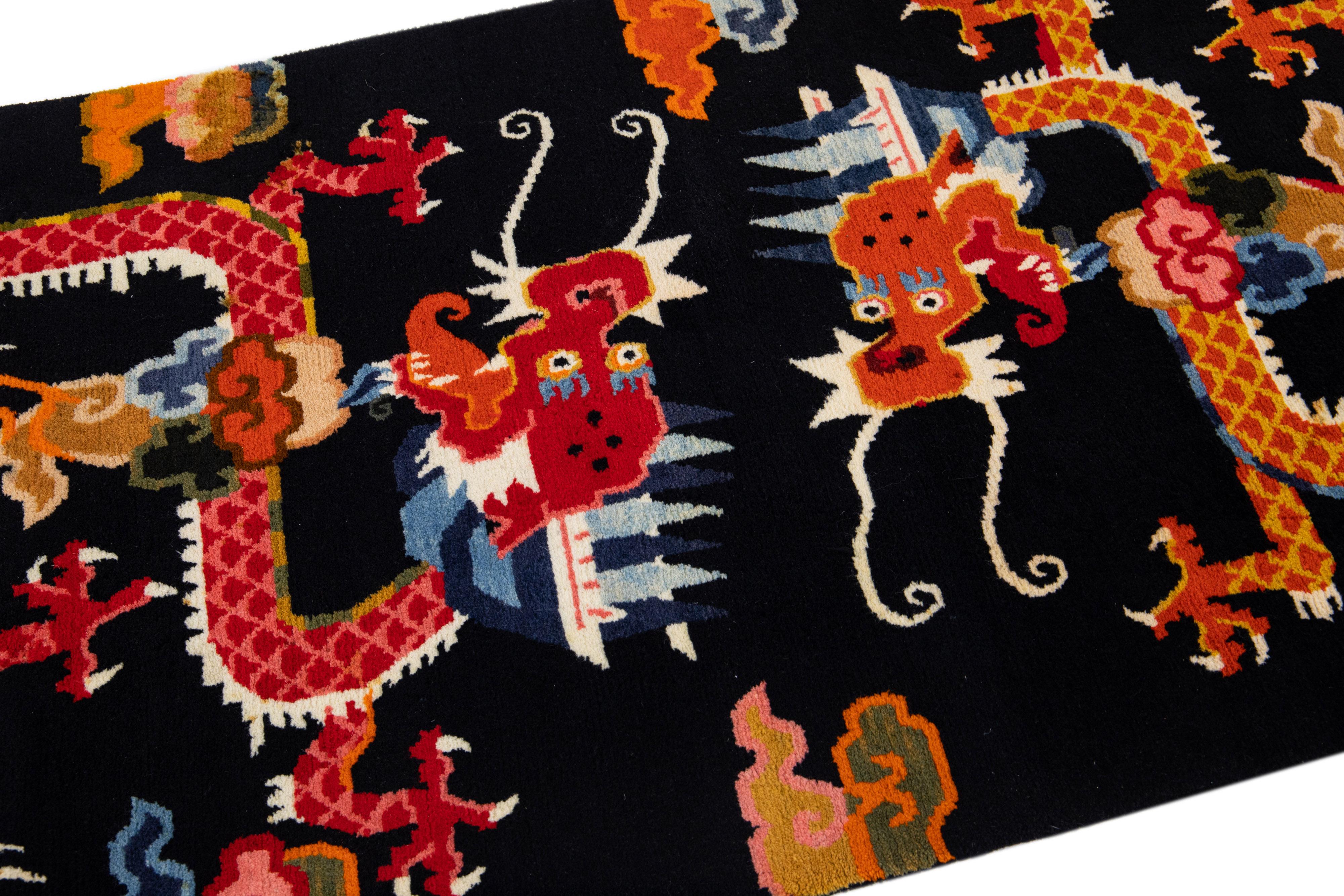 Magnifique tapis chinois ancien en laine nouée à la main avec un champ noir. Cette pièce présente des accents rouges et orange sur l'ensemble des motifs traditionnels de dragons chinois. 

Ce tapis mesure 3'1