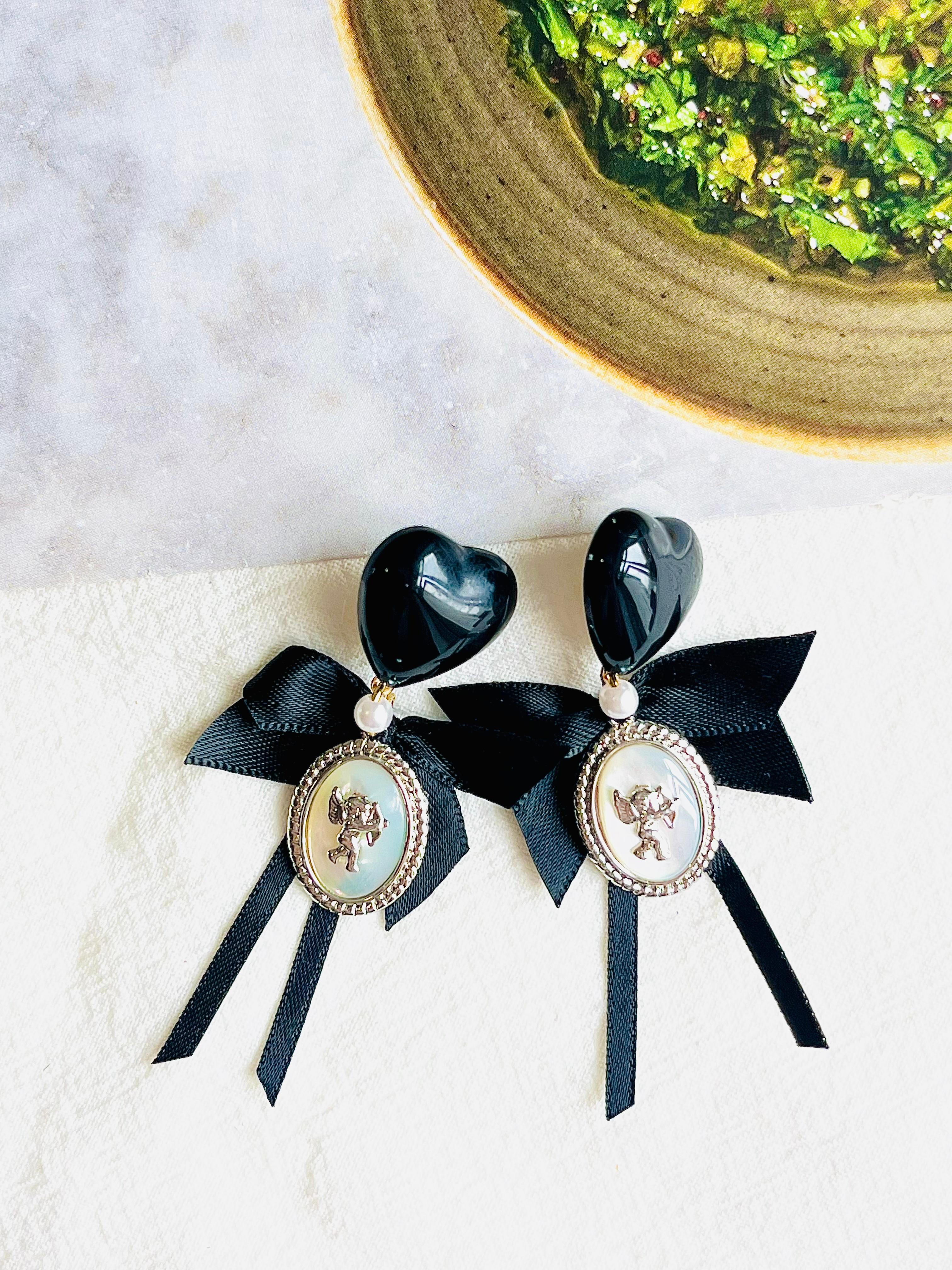 Black Heart Love Bow Silver Cupid Angel Moonstone Retro Pierced Earrings, Swarovski Element

High quality and handmade. Excellent gift for lady.

Wear them on casual, prom, holiday...

Material: Cloth, Alloy, Faux stone.

Size: 5.8*4.5 cm.

Weight: