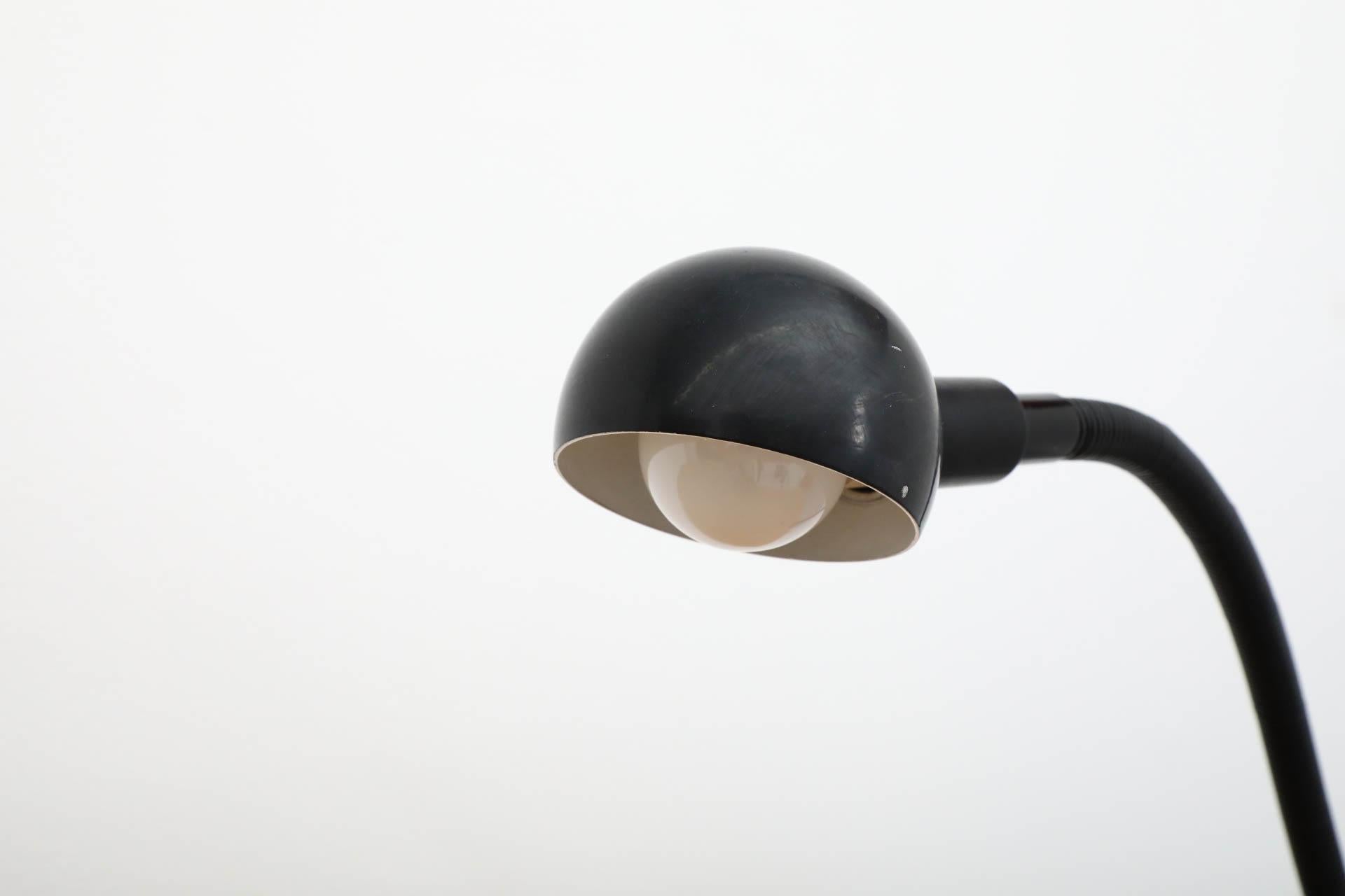 Versatile and adjustable black clamp on lamp with black enameled metal shade. Isao Hosoe's Hebi Table Lamp, designed for Valenti Luce in 1970, is a true modern design classic. Hosoe, a Japanese native, moved to Italy in his early twenties to open