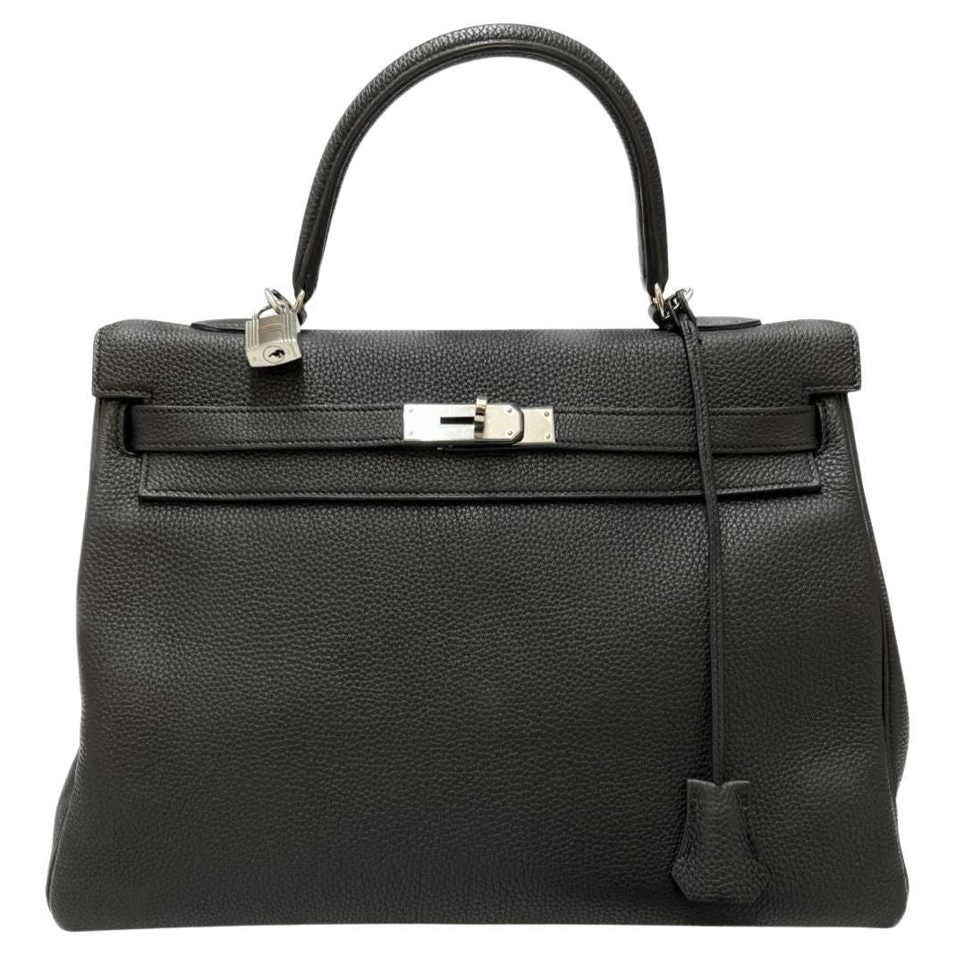 BEAUTIFUL black retourné Kelly 35 bag from the House of HERMES from the collection Kelly II in black togo leather with its silver jewelry. It has its padlock, its clochette and keys (two). The interior is in leather. This bag has the letter T; it