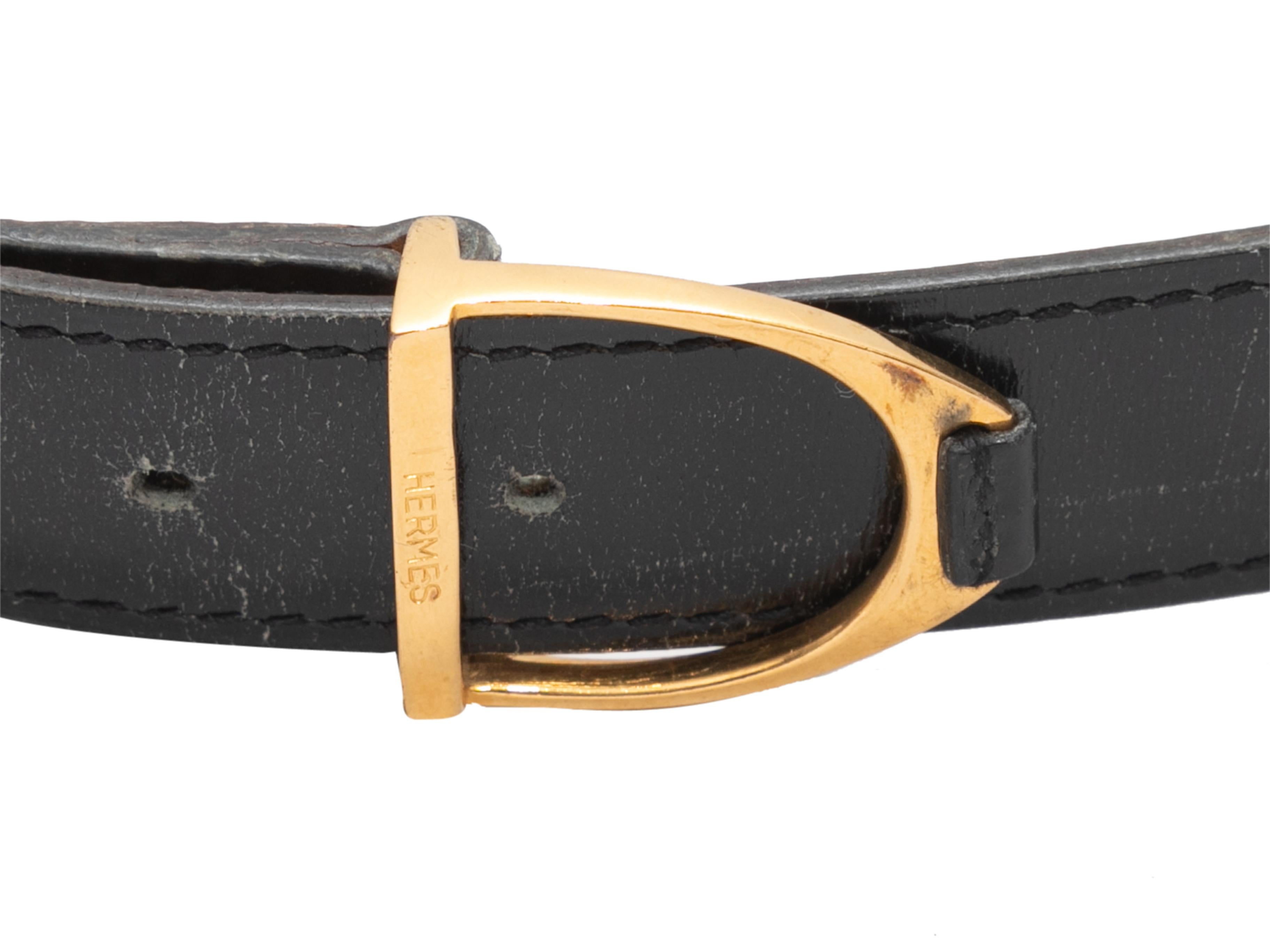 Black skinny leather belt by Hermes. Gold-tone peg-in-hole closure. 0.4