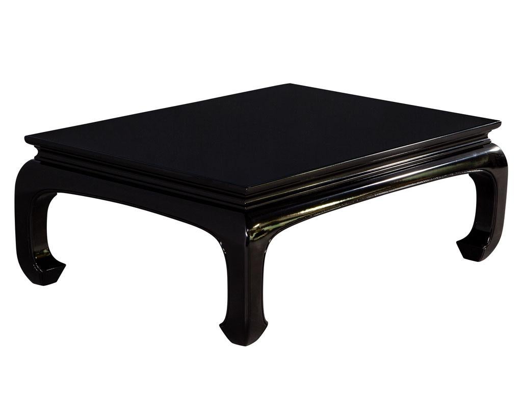 Black high gloss polished coffee table. Mid-Century Modern inspired with a chinoiserie flare. Beautiful, curved legs with sleek modernist design. Finished in a high gloss polished black lacquer. Price includes complimentary curb side delivery to the