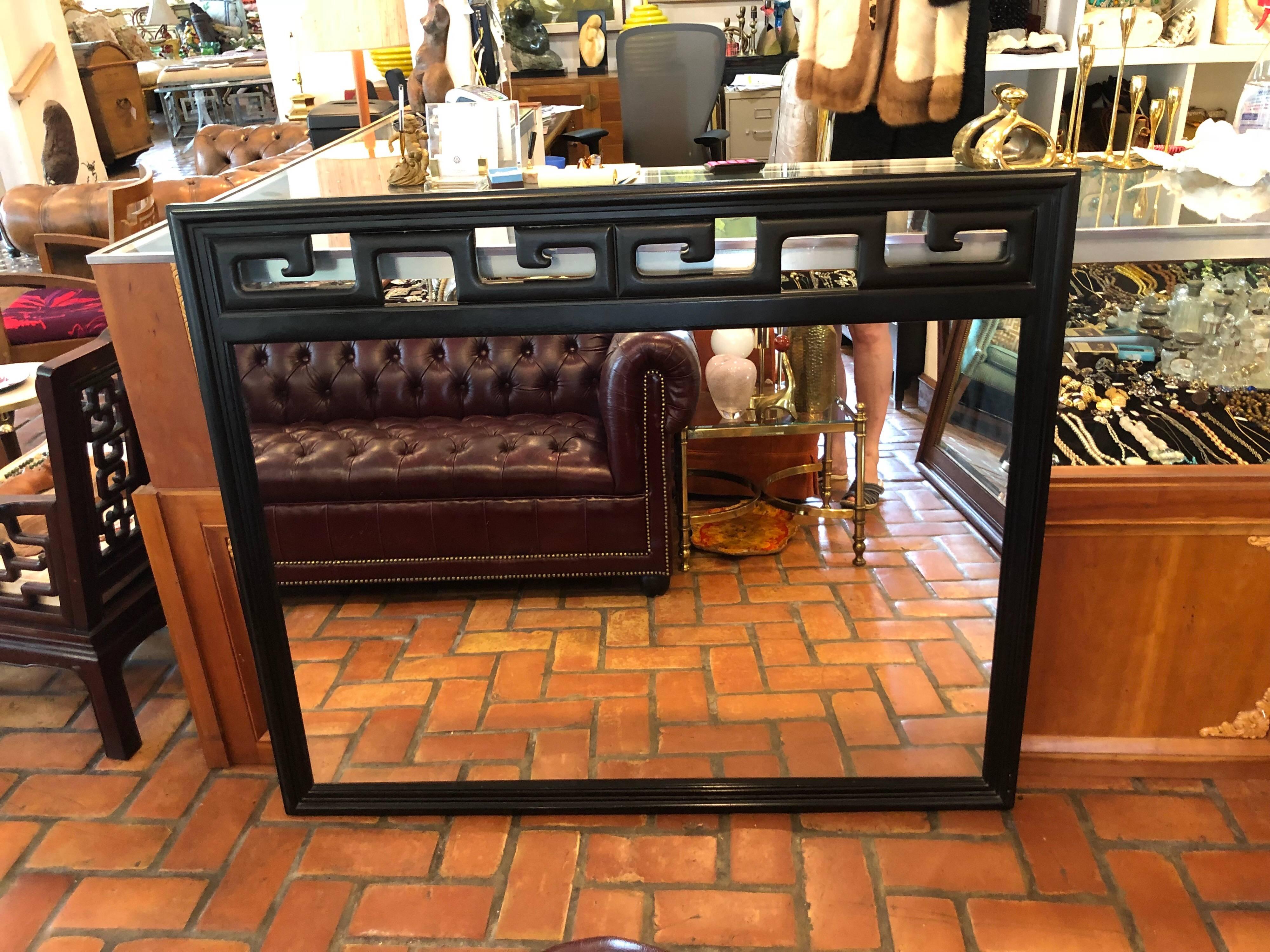 Black Hollywood Regency mirror in the style of James Mont. Classic lines and fabulous Greek Key design make up this beauty. It looks great above a credenza or a fireplace. The original credenza has already sold. Please request a shipping quote as